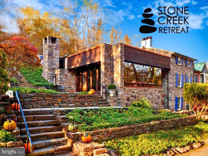 This strikingly original Lumberville estate, perched high above the cascading Paunnacussing Creek, has been forged by over three centuries of avant-garde style. The brilliant unification consists of a 1700s stacked-stone house, a 1800s Victorian annex and a 1900s stone-and-glass annex. Its calculated evolution stands as a testament, to the allure of its immersive location, and the uniqueness of its design. Enter the main living space and watch with wonder as it surpasses functionality, and dives into the abstract. A sea-of-slate flooring and window-walls impress, and the home’s nimble Phillips-Hue color-changing programmable lighting system boosts your ability to customize. The adjacent kitchen is adorned with hidden surprises, with sleek Mercer tiles, refinished cabinetry with new hardware, and state-of-the-art appliances. The Primary Suite, located on the home’s main level, is defined by extravagance—  the room is adorned with newly installed Rifle Company wallpaper, an exposed stone wall, heated marble flooring and soaring cathedral ceilings. There is a fireplace, an incredible full bath with multiple sinks, a walk-in shower, and abundant closet space to house your wardrobes. French doors offer access to the rear patio, with views reminiscent of a European landscape. From the kitchen, original pie stairs lead up to the second floor, where there is a full bathroom, bedroom and access to a luxurious roof deck. The ground level is a treasure trove of delights, including another charming fireplace, sophisticated built-ins (complete with a sneaky Murphy bed!), a full bathroom, wine cellar, laundry sanctuary, and a bluestone three-seasons room. The estate's grounds are a botanical wonderland exhibiting stone terraces, walkways and gardens, a koi pond, fountains, and a vintage greenhouse for the cultivation of one’s very own fruits, vegetables, and herbs. Positioned just steps away from the Main House is the separate 1700s wooden and slate-roofed Carriage House, with its own Victorian-era annex (providing secondary living quarters for offices and/or a guest house). This estate is as fabulous as it gets, listed on the National Register of Historic Places, and featured in publications such as The New York Times. Few interior design styles have captivated our imaginations the way “Stone Creek Retreat” has, behaving as an exemplary example of modernism in its warmest and most creative state. Free your mind and soul, with sophisticated wonder, at this Bucks County marvel.
**Flood insurance is $1,000 per year. The  policy is grandfathered in and is fully transferable to Buyer. Extensive property upgrades (totaling over 200k+) are listed in the photo gallery as well as a tremendous amount of property inclusions.**