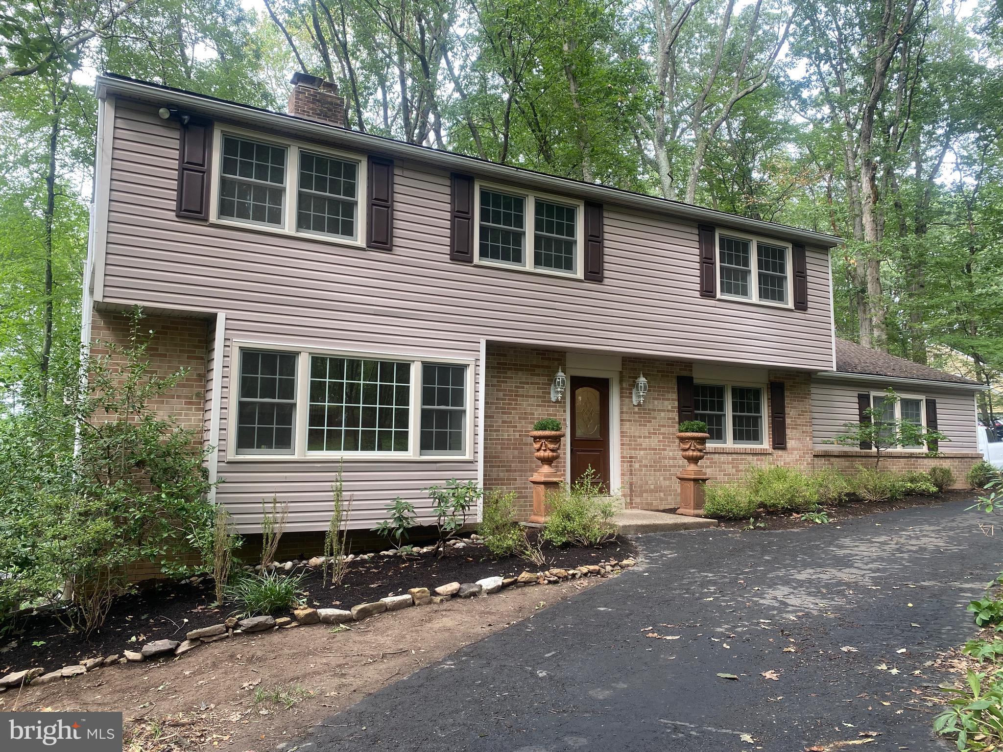 Welcome to 3015 Yorkshire Road, a beautifully renovated 5-bedroom, 2 full bath - 2 half bath home in move-in condition! Situated on a 1+ acre partially wooded lot with a circular driveway, this property offers fantastic curb appeal. The main level, featuring refinished hardwood floors, is bright and airy with plenty of room to relax and entertain. The formal living room boasts a stunning brick double sided wood-burning fireplace, crown molding, chair rail, and oversized replacement windows. The dining room seamlessly flows into the brand-new gourmet kitchen, which includes stainless steel appliances, white cabinetry, a center island, and granite countertops. The cozy family room, complete with another wood-burning fireplace, hardwood floors, crown molding, and a half bath, adds to the charm. A dedicated laundry room with built-in cabinetry and access to the two-car garage provides additional convenience. Upstairs, you’ll find five spacious bedrooms and two full bathrooms. The primary suite includes a walk-in closet, and a private ensuite bath. The remaining bedrooms, all featuring hardwood floors, are generously sized, and a large hall bathroom with a jetted tub and separate shower serves them. The newly finished walk-out basement spans 852 square feet, offering endless possibilities for a recreation room, home gym, office, plus additional storage. Outside, a large deck overlooking the backyard surrounded by mature trees, providing privacy and a tranquil setting. Located just minutes from Route 202, this home is close to Doylestown’s shopping, dining, and cultural attractions.