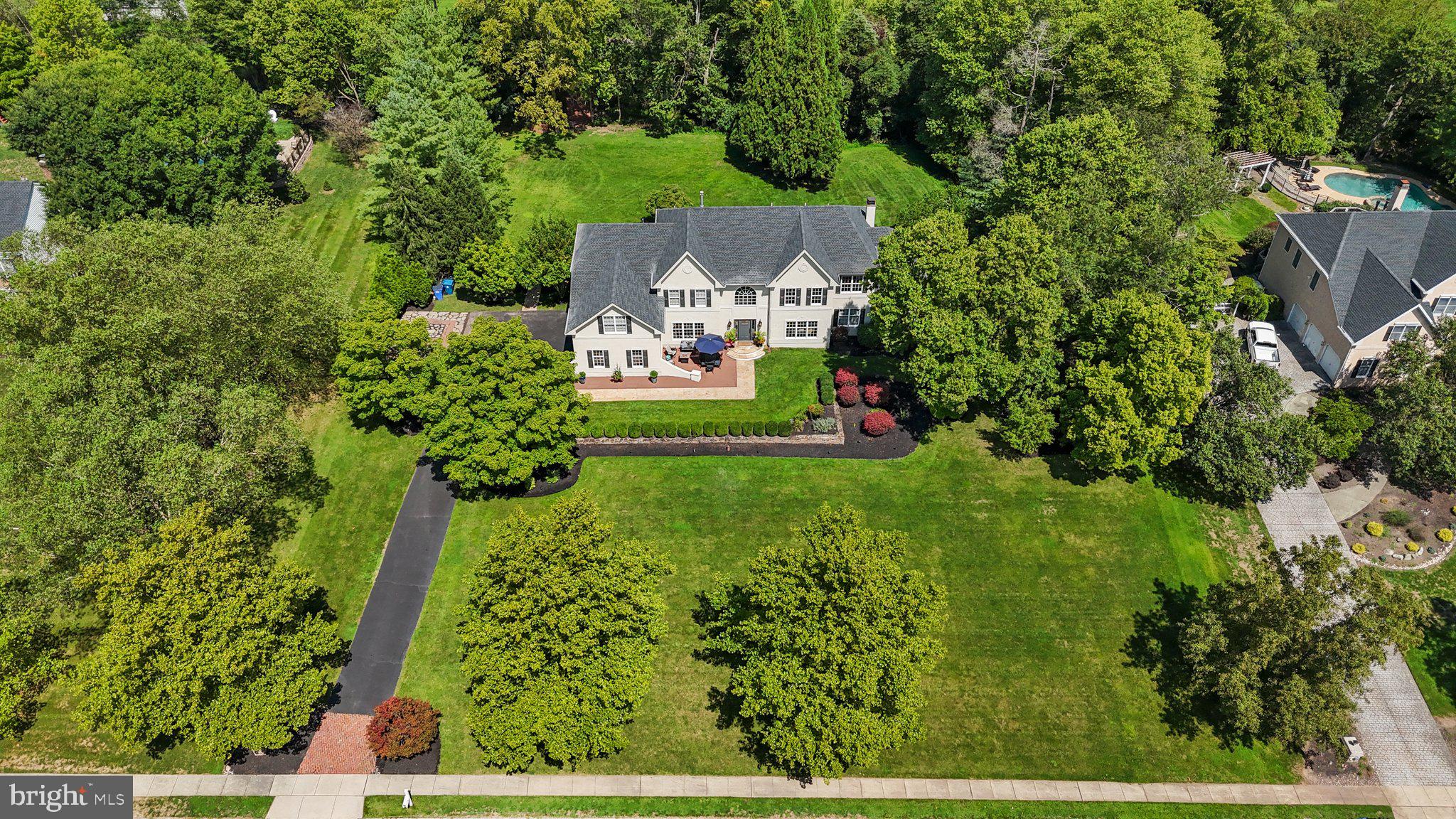 A LIGHT AND BRIGHT HOME FILLED WITH POSITIVE ENERGY AND SERENITY! Welcome to 26 Woodside Lane located in historic New Hope, Bucks County. Introducing this magnificently crafted, five bedroom, three and one half bathroom estate property located in the sought after upscale community of River Crossing, Upper Makefield Township, PA! Majestically set on 1.24 acres, the current owners have filled this charming home with an uncompromising level of quality, custom finishes and attention to detail that is rarely seen at this price point. This South facing, light drenched home begins with a walk down a long Tennessee sandstone walkway that leads to the main entrance. The 2-story foyer with turned staircase featuring decorative wrought-iron spindles and gleaming hardwood floors is flanked on the left by the expansive dining with custom tray ceiling and on the right by the transitional living room. Double French style doors from the living room lead to a first floor study with mahogany floors and custom mahogany ceiling. Perhaps the most enjoyed area of any home is the kitchen and great room areas. Without exception, this Woodside Lane property offers plenty of memorable moments. The kitchen features cherry wood cabinets, reclaimed barn wood ceiling, Dakota Mahogany granite counters, Italian tile backsplash, expanded plant window with skylight and vaulted ceiling, newer double oven and induction cooktop, butler's pantry, two story dining area and a back staircase leading to the second level. The kitchen opens directly to the great room with walls of windows, gas fireplace with fieldstone surround and raised stone hearth and an artesian style coffered ceiling. Adding more special space to this exceptional home is the large sunroom just off the great room area. This space offers gorgeous panoramic views, vaulted ceiling and a wonderful place to enjoy your morning cup of coffee. The mudroom with washer & dryer leading from the 3 car garage and the first floor powder room complete the main level. Upstairs is the main bedroom suite featuring detailed Venetian plaster, hardwood flooring, two walk-in closets, sitting room area, and the main bathroom with Carrara marble & oversized tub. There are 4 additional bedrooms and two more shared bathrooms and new carpeting that complete the second level. A full unfinished basement below allows for some creative plans ideas and plenty of additional storage space. Outside is an oasis featuring Tennessee sandstone walkways and patio. In front, the current owners have set up a cozy sitting area that offers great views. Out back is the patio area surrounded by mature European inspired landscape design. The extra special feature in the rear yard includes a private pathway into a 37 acre Township owned park called Lookout Park! This is a great place for walking, pets and quiet enjoyment. Location, Location as this property is located near Jericho National Golf Club and the current owners have a golf cart they drive to the course! Enjoy great shopping and fabulous dining in the quaint town of New Hope. Located in the award winning Council Rock School District. Neutral throughout, move right in and make this beautiful home yours!