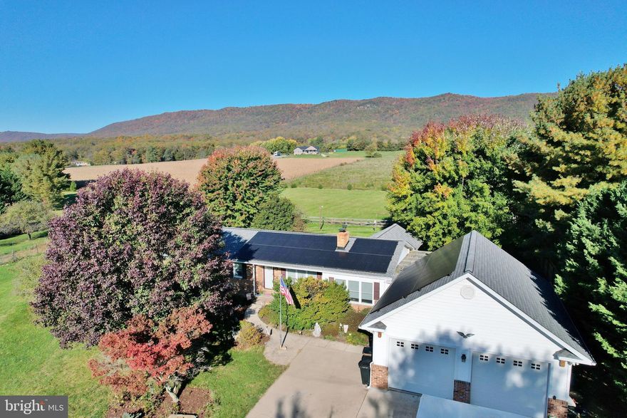 Nestled in the Shenandoah Valley with Beautiful Mountain Views is this Spacious Ranch Home on 4.4+ Acres of Prime Real Estate. Plenty of Room to Plant a Large Garden next to the Fruit Trees and Grape Vines! Summary of Noteworthy Features that make this property stand out from the rest include a Paved Concrete Driveway, Attached Two Car Garage, Four Seasons Room, Fenced Backyard, Gourmet White Kitchen, Entertaining Rear Deck and Large Garden Patio. Full Basement with Tons of Space and Additional Living Area. Solar Panels and Solar House Generator System conveys to Purchaser! No HOA!
DRIVEWAY: Fully Paved Concrete Driveway with Large Area in Front of Garage for washing vehicles, Extra Parking. 
GARAGE: Two-Bay Attached Garage with High Ceilings, and a Separate Storage/Workshop Room, Enclosed Breezeway to the Residence!
KITCHEN: Beautiful White Gourmet Kitchen with a spacious dark wood Island with Seating. Upgraded Solid white Countertops! Upper Cabinets with Lighting, Attractive Backsplash, Sink with Garbage Disposal, Stainless and Black Appliances. Office Area too!
FOUR SEASONS ROOM: Fully Finished with LOTS of Glass and Clear Mountain Views! Sliding Glass Doors that lead to either the Rear Deck or Garden Patio! Mini-Split Heat and AC!
FAMILY ROOM: Spacious Family Room with Wood Flooring, Windows, and Access to Four Seasons Room and Breezeway. Ceiling Fans!
REAR DECK: Composite Decking with Vinyl Railing
GARDEN PATIO: Amazing Paver Patio that has a Built In Fire Pit and Seating with Mountain Views! Existing Hot Tub Conveys As-Is, Hot Tub Hook-up! Deck to Storage over Garage!
SOLAR: Conveys to Purchaser! Full Scale Solar Panel System and Solar Power Storage Whole-House Generator! Seller notes Electric Bills typically Average $35-40/Monthly! System is less than 5 years old!
PRIMARY BEDROOM: Oversized Room with multiple closets, Crown Molding, Half Bath
BASEMENT: Fully Finished, Multiple Large Rooms for Recreation, Storage, or More Living Space. Second Full Bath with Walk-In Shower, Second Laundry Hookup (First hookup is on Main Level - Bathroom closet), Laundry Counter Space and Cabinetry, Mud Room with Slop Sink and Basement Walk-Out, Cedar Room for Clothing Storage, and Built-In Storage Cabinetry Hallway.\
BACKYARD: Fully Fenced Approx. 5 years ago, Ready for Pets!
GARDEN/ORCHARD: Large Garden Area and small orchard of Fruit Trees!