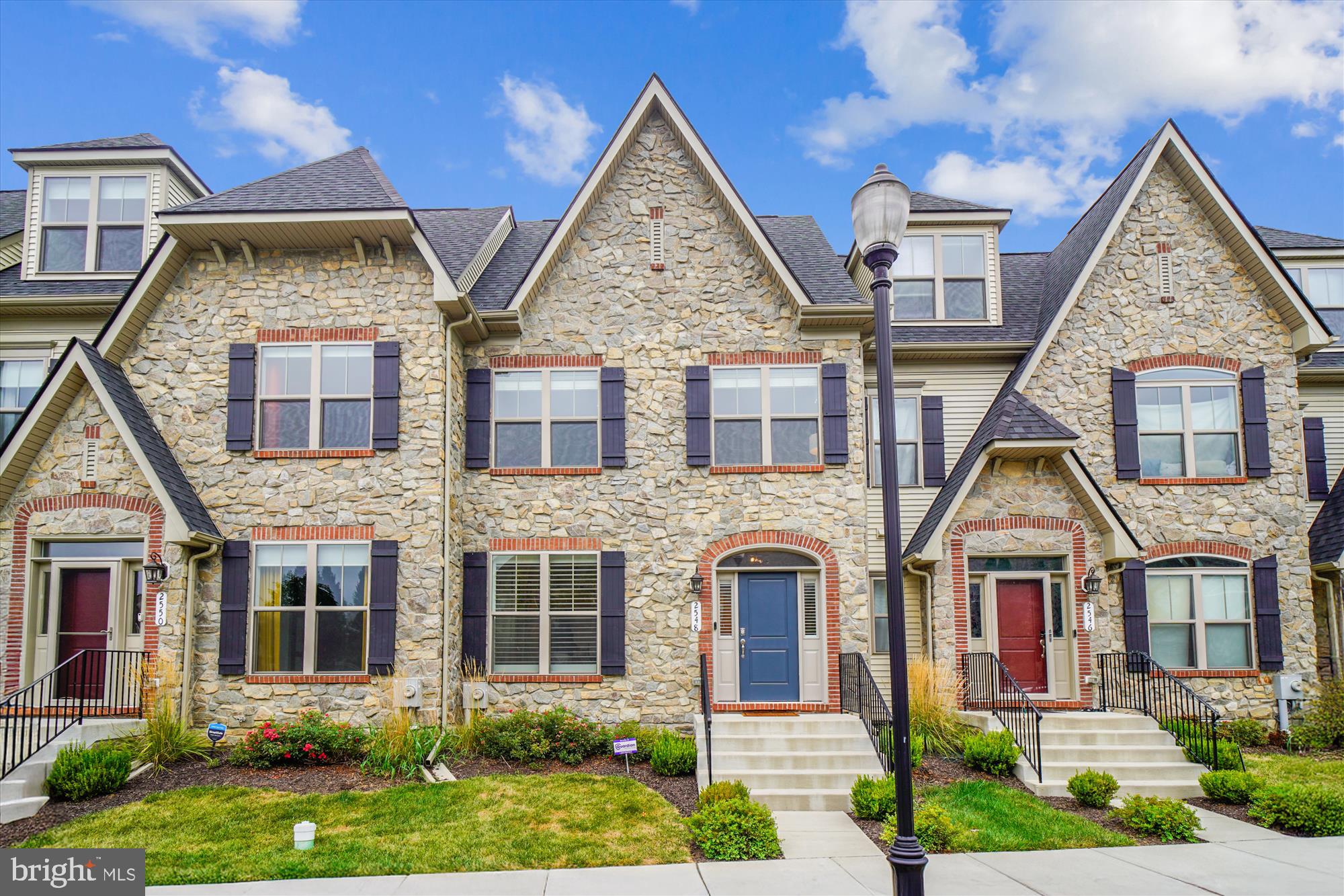 Timeless elegance meets modern sophistication in this exquisite four-level townhome located in the prestigious Mill Island enclave of Worman’s Mill. With close to 3,000 square feet of impeccably curated living space, this residence offers a rare blend of architectural charm, upscale finishes, and thoughtful design. From the moment you arrive, the stately stone front façade and classic colonial French lines set the tone for what lies within. Step through the arched entryway into a light-filled interior adorned with custom window treatments, including plantation shutters and tailored blinds that enhance both privacy and style. The main level boasts an open-concept layout ideal for entertaining, anchored by a gourmet kitchen featuring upgraded cabinets, back-splash, countertops, and stainless steel appliances. Adjacent, the spacious great room flows seamlessly into a private rear courtyard—perfect for al fresco dining or quiet morning coffee. A standout feature is the library/study, enclosed by elegant custom barn doors, offering a serene retreat for work or reading. Upstairs, the owner’s suite is a sanctuary of comfort, complete with tray ceilings, dual walk-in closets, and a spa-inspired bath showcasing designer tilework, a freestanding soaking tub, and a glass-enclosed shower with built-in seating. The top-level loft provides a versatile space for lounging or entertaining, opening onto a covered sky terrace with sweeping views—ideal for sunset cocktails or stargazing. The lower level is equally impressive, featuring a wet bar, expansive family/rec room, and full bath, creating the perfect setting for game nights or guest accommodations. Additional highlights include a rear-entry two-car garage, upgraded lighting throughout, and access to the vibrant Worman’s Mill Village Center, with boutique shopping, dining, and community events just steps away. Conveniently located near Rt. 15, I-270, and I-70, this home offers effortless access to downtown Frederick and beyond. 2548 Island Grove Blvd is more than a residence—it’s a lifestyle. Experience refined living in one of Frederick’s most coveted communities.