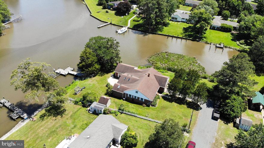 Don't miss out on this amazing home with nearly 300' of waterfront and views of the water from nearly every room!   The home has 4 bedrooms and 3.5 baths, 2 car garage, beautiful hardwood floors, featured ceilings, built-in shelving, a gas fireplace, and an abundance of storage space.   The main level includes 3 bedrooms, 3.5 baths, living room, dining room that is open to the kitchen, family room and a large sunroom with vaulted ceilings and skylights.   The upper level bonus area can be used for bedrooms/office/den/storage.  A private pier with electric and lift.   Upgrades include:  new 200 amp electrical panel, new carpet in FR, majority of new windows 2024, ac replaced in primary bedroom 2023 and more.   One of the most enchanting features of this waterfront property is the vibrant and diverse wildlife that calls the area home.   Whether you're an avid birdwatcher, a nature enthusiast, or simply enjoy the tranquility of the outdoors, this home offers a front row seat to a rich natural landscape right outside your door.   From the comfort of your private dock, you can regularly spot majestic bald eagles and osprey soaring overhead, graceful blue herons wading along the shoreline, and a variety of waterfowl including ducks and geese gliding across the water.   The dock area also provides frequent sightings of terrapin turtles sunning themselves, playful muskrats in the shallows, and even the occasional fox making its way through the nearby brush.  Anglers and marine life enthusiasts will also appreciate the abundance of fish available to catch right off your private pier, it is also perfect for crabbing -- a favorite local pastime!!