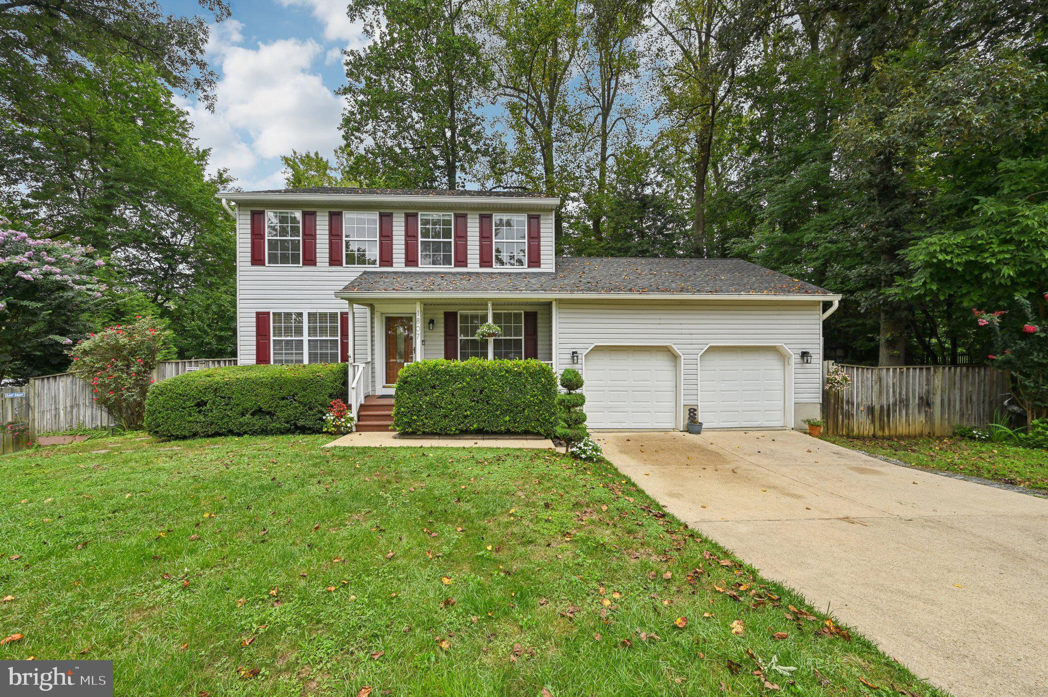 Welcome home to this beautiful property set on a gorgeous lot with mature trees and thoughtfully designed landscaping. A long driveway leads to the inviting front porch and fenced yard with parking made easy. Inside, hardwood floors span the main level, featuring a formal dining and living room, plus a cozy family room with a brick-accented fireplace. The eat-in kitchen offers stainless steel appliances, ample cabinetry, and a custom backsplash. Step outside from the family room to a large deck with stairs leading to the backyard and patio, perfect for outdoor entertaining. Upstairs, you’ll find generously sized bedrooms, including the primary suite with a dual vanity and stand-up shower. The finished basement adds versatility with an additional room and walkout access to the yard and deck. This home offers space, comfort, and charm, both inside and out!