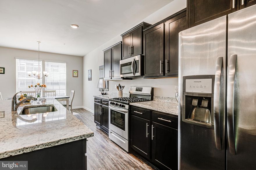 *** BUYER ISSUES*** LOOKING FOR BACK UP OFFERS!***YOU WOULD NOT BELIEVE THIS IS NOT A MODEL HOME!!   LIKE NEW AND GENTLY LIVED IN!! This luxury townhouse is in the highly sought after Odenton Town Center Community... just minutes away from Ft. Meade! This floor-plan features over 2100 Sq Ft  Luxury within Three Levels, boasting Three Bedrooms, Two Full and One Half Bath- Located Deep in the Community- Private BackYard- No Neighbors BehInd You. Starting from the Foyer, You'll Notice the Welcoming Entryway which takes you into a Spacious Family or Entertaining Space featuring 9ft ceilings, Recessed Lighting, and Direct Access to your Private Fenced in Backyard.  This is also a full bathroom rough in on this level for future home additions. The Staircase Leading Up to the Main Floor is an Open Concept with Center Kitchen. The Oversized Kitchen Island has Seating for Four! Pristine Granite Countertops, 42" inch cabinets, Recessed Lighting, SS Appliances, Gas Cooking, Spacious Pantry and Contemporary Rustic Styled Luxury Vinyl Plank Flooring Throughout.  Tons of Natural Light. Spacious Dining Area, Sitting Area, Great Room with Extended Living Space plus a Large Rear Deck, with NO ONE BEHIND YOU. 
The Primary Bedroom on the Upper Level with Walk-in Closet has a Spa-Like Primary Bath with a Dual Vanity, Granite Counters Tops, Separate Large  Floor to Ceiling Tiled Shower. Two Additional Bedrooms, Hall Bath and Laundry Room w/ full size Washer and Dryer Complete this Level. Enjoy a Comfortable, Low Maintenance Lifestyle in Odenton's Newest Community. Convenient Location to Shopping, Dining and Commuter Routes. The community offers a wonderful play area for children, walking / jogging / biking path. Minutes from Ft. Meade, MARC Station, BWI Airport and easy access to both D.C. , Annapolis and Baltimore.