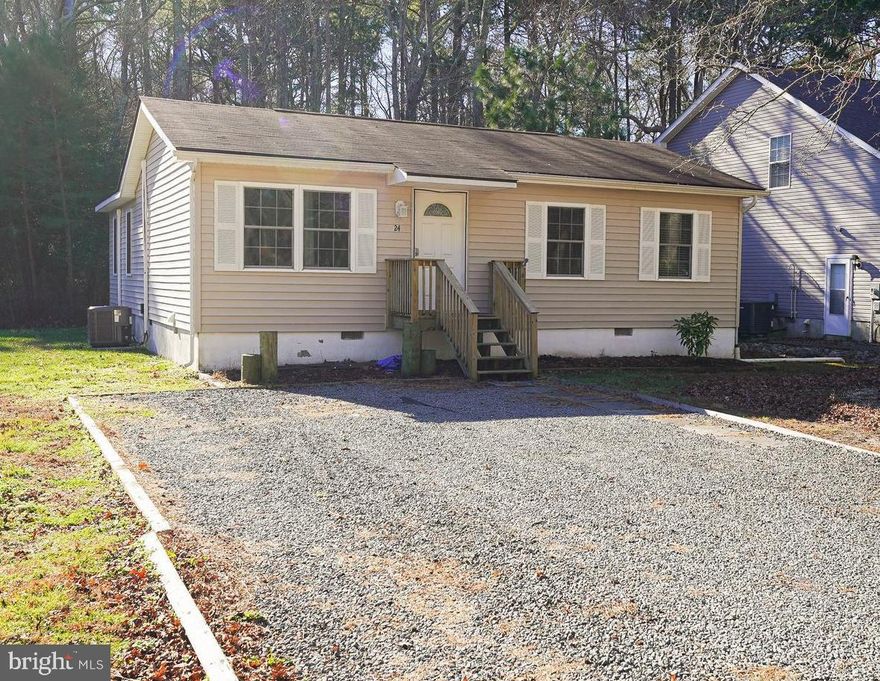 Welcome to 24 Quarter Staff Place, your gateway to gracious living in the heart of the Sherwood Forest section of Ocean Pines. This enchanting residence, with 2 bedrooms and 1 bathroom spread across over 1,100 square feet, eagerly awaits its new stewards. Whether embarking on your homeownership journey, seeking a cozy abode for downsizing, or anything in between, this home beckons with its timeless charm.

As you step inside, be embraced by the luminosity of light-hued hardwood floors, harmonizing seamlessly with the abundant natural light that bathes every corner. The canvas is set, awaiting your personal strokes, as fresh paint whispers an invitation to transform this house into your unique sanctuary. The kitchen, a culinary haven, boasts granite countertops, stainless steel appliances, and pristine white cabinetry adorned with soft-close hardware. Clear glass cabinet doors, a farmhouse-style sink, and a tasteful grey subway tile backsplash bestow a modern yet inviting ambiance, ready for your culinary endeavors.

Flowing effortlessly from the kitchen, the living room with a bar and kneewall creates an open floorplan, crowned by a vaulted ceiling that amplifies the sense of spaciousness. Step out onto the rear deck, a private retreat overlooking a wooded backyard, a thoughtfully designed space perfect for hosting gatherings and creating lasting memories.

The bathroom is a sanctuary of its own, featuring a walk-in shower with glass doors for easy maintenance, accompanied by a linen closet for additional storage. Bedrooms are generously appointed with deep closets, while a stackable front-loading laundry and a second living room optimize the home's efficiency. Endure the seasons with tranquility, knowing that the HVAC system was replaced in 2020, complemented by a supplemental ductless HVAC unit.

Situated just minutes away from the allure of America's Coolest Small Town, this residence is also a short drive from the sun-kissed shores of Maryland and Delaware Beaches. Enjoy the plethora of dining, entertainment, nightlife, shopping, and recreational activities that Ocean City offers, while benefiting from Ocean Pines' amenities such as golfing, marinas, parks, trails, and shopping. Your dream home awaits – call today to embark on your exclusive private tour!