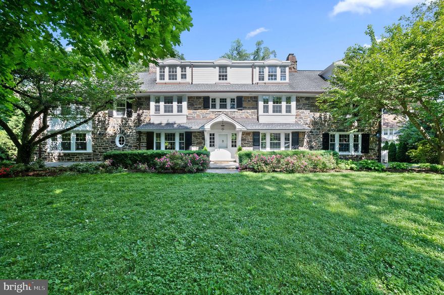 This Quintessential Main Line Stone Colonial is the perfect combination of old world elegance and modern updates in a “walk-to” Ardmore & Suburban Square location. Set on 1.25 acres of manicured grounds the stone pillars and wrought iron gate are an indication of what awaits beyond, including mature gardens and handsome stone garden walls.  This stately residence offers a tranquil retreat with a renovated heated saltwater swimming pool, detached garage/ pool house, and tennis court. Built in 1880 and most recently meticulously remodeled in 2019 this home offers everything you love about estates of this era, like high ceilings, spacious rooms with large windows and decorative wood moldings, and romantic flagstone terraces, combined with updated infrastructure and new designer custom kitchen & sumptuous baths. The grand entry foyer is flanked by the Formal Living Room and Dining Room. The living room features charming built-ins, a wood burning fireplace and french doors opening to the covered flagstone terrace overlooking the grounds. The Living Room leads to the study with a marble surround gas fireplace, custom wood paneling, built-ins and access to the covered terrace, as well as a back staircase to the primary suite.  The dining room is open and light filled with an additional sitting area with stunning built-ins and a new state of the art wet bar with full slab marble backsplash. The generously sized family room, with a wall of large windows, beautiful ornate moldings and wood burning fireplace is just beyond the dining room.  The spectacular kitchen is not only beautiful but functional with radiant heated floors, white lacquer custom cabinetry, subzero side by side refrigerator-freezer, wolf 6 burner gas range, 2 Miele dishwashers, Wolf double ovens, full slab Calacatta Marble backsplash, sub zero 105 bottle wine fridge, and stunning waterfall edge countertop island with seating for 5.  Adjacent to the kitchen is a sunny breakfast room, surrounded by windows with a new built in pantry and french doors to the new trex deck perfect for sipping a morning coffee. Upstairs the primary suite has a large sitting room with beautiful wood bookcases and marble surround fireplace.  The bedroom is light filled with a built-in window seat overlooking the grounds and a new large california custom walk in closet. The luxurious Primary bath has statuary marble tile, frameless glass shower with rain shower and body sprays, separate floating custom vanities, an oversized jacuzzi tub with radiant heated floors and a private w/c. The second bedroom suite has a newly renovated bath w radiant heated floors and a walk in California closet. Bedroom three & four both have custom outfitted closets and share a renovated hall bath. Beyond the back staircase and a full sized laundry room with linen storage is bedroom five- an en Suite with a custom walk-in closet, new bath with Carrara marble and custom cabinetry.  The third floor offers additional space and ample storage with two bedrooms sharing an original jack and jill bath, there is also a large room which makes a great family room. The walkout lower level has a mudroom w bench seat & cubbies, a powder room and family room with original wood moldings and a  fireplace, in addition to an abundance of storage. Outside the quiet grounds are a stunning retreat, from the relaxing pool area tucked away from view of the home with jacuzzi and waterfall to the pool house, with kitchenette, bathroom and changing area. The tennis court is in as-is condition. With all stone construction, new windows, new roof (2021), new rain gutters (2019), new mechanicals and systems including boiler, AC units, wifi controlled recessed lighting, whole house generator, this home offers quality construction, distinguished architecture, and a sought after lifestyle. In Award Winning Lower Merion SD within walking distance to all Ardmore has to offer including the train, easy access to highways, center city & the Main Line.
