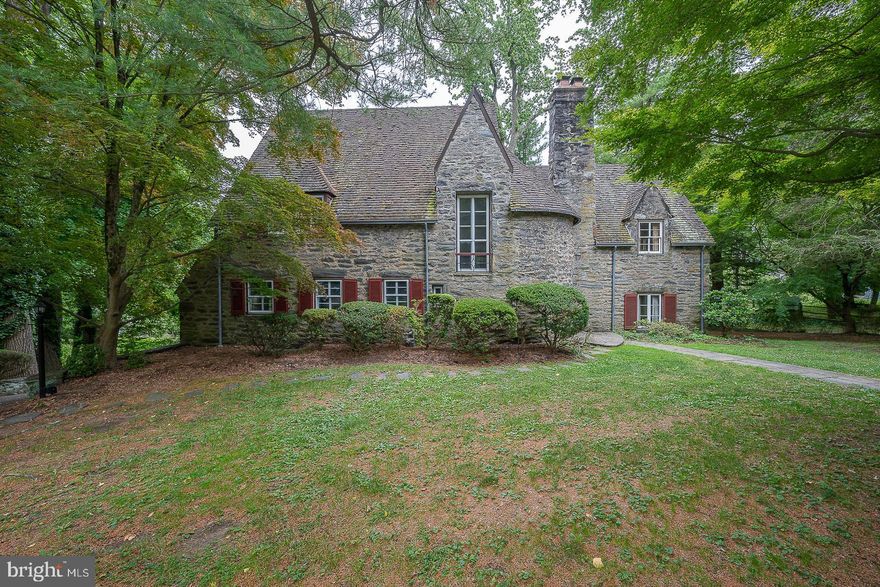 Designed by famous Main Line architect Walter K. Durham, this lovely home is built of local stone (Wissahickon schist) in the French Norman style. It contains some of Durham's signature details such as the turret and interior rounded walls. The front entry hall is impressive with slate floor, cathedral ceiling, and curving staircase with wrought iron bannister. Step down into the generous sized living room, with hardwood floors, and abundant windows. The front wall is richly paneled and includes several built-in shelves, a wood-burning fireplace, comfy window seat with storage below, and even a "secret" cabinet. The back wall overlooks the flagstone terrace which is accessed through a Dutch door.  The dining room is a sunny, welcoming place with east facing windows, lovely hardwood French doors, and also has access to the terrace. Exit through the swinging door to the wonderful butler's pantry with glass fronted cabinets for your entertaining china and glassware. A bar sink is also located here. The kitchen includes a breakfast bar and a walk-in pantry closet. Like any 94 year old dowager, some upkeep is necessary here. Off the kitchen are a full bath and two smaller offices/bedrooms which serve originally as the servant's quarters. A favorite feature of the home is the original bell system, used to summon the servants to the back door, front door, living room or one of the bedrooms.

Follow the curving staircase to the second floor and take two steps down to the primary bedroom suite. This room has two closets, one with built-in drawers and shelves, and wide window sills over looking the front, back, and side yards. The bedroom has hardwood floors and the bathroom here has a tile floor and a large walk-in shower. Return to the upstairs hallway where you will find three generously sized bedrooms all with hardwood floors and windows looking out in two directions. Two of the bedrooms have mirrored  closet doors and two have wide window sills. The hall bath, with tiled floor has a tub with shower and across the hall is a linen closet.

There is a full walk-up attic with a wood floor and a large cedar closet. The storage possibilities up here are endless. There is also a full, unfinished basement with laundry and potential for a workshop or game room. A waterproofing system is guaranteed and transfers to the new owner. Walk out at grade to the driveway and the two car garage with entry from the back of the house. Outside you will find a covered back porch and a flagstone patio. The lot contains many large, shade trees for privacy and comfort. This highly sought after neighborhood is close to schools, services, and shopping and just a mile from the Haverford train station. If you don’t mind a few updating projects, come and take a look at your new home! Listing agent is executor of this estate.