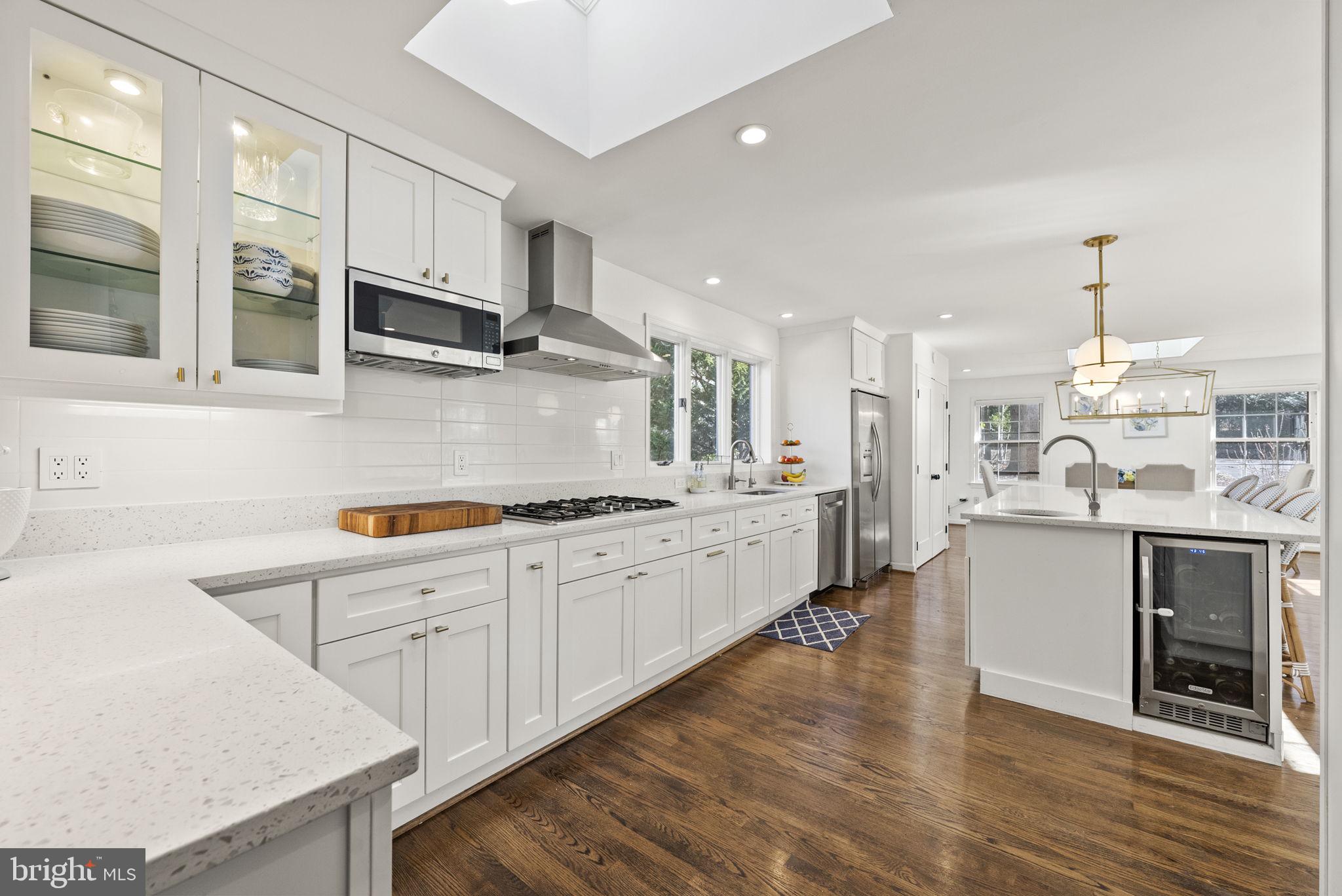 Design conscious and aesthetically stunning fully renovated rambler style home in the highly sought after heart of Mclean boasting a wide range of updates, a main level bedroom, and a Gourmet Kitchen worthy of any chef or regular entertainer. This 4 bed, 3 bath home offers a main level living space with fully remodeled Kitchen and Bathrooms, as well as upgraded and upper level washer and dryer, newly installed fitness area, upgraded vanities, fresh painting and molding, and upgraded washer/dryer. Robust with natural light and skylights throughout the upper level, this home encompasses the best components of both private living and accessibility to the outdoors. The Gourmet Kitchen features Quartz countertops, stainless steel appliances, an expansive island, and washer & dryer in closet which have recently been upgraded to new units. The main level also boasts a large breakfast and open concept formal dining area which is enhanced by built in skylights and window light providing a warm and light enriched environment for entertaining guests and family. The lower level provides a large finished recreation area, additional master suite, full bath, finished gym with upgraded flooring, custom wine cellar, and ample storage. In addition, the lower level living area has immediate access to the 3 car garage which has additional storage, a large and private driveway with separate guest parking for up to 2 cars, and the rear outdoor space and rear entry. The front yard offers a circular driveway, exterior sod and mulched living space for outdoor activities, and a driveway leading to private parking at the rear of the home. The rear and side exteriors of the home offer a private fenced in backyard enriched with hardscaping, a updated private deck with access to the main living level, and rear entry to the lower level of the home. Located just blocks from the heart of Mclean, this home has access to all of the desirable features of the community, transit, and shops and retail.
