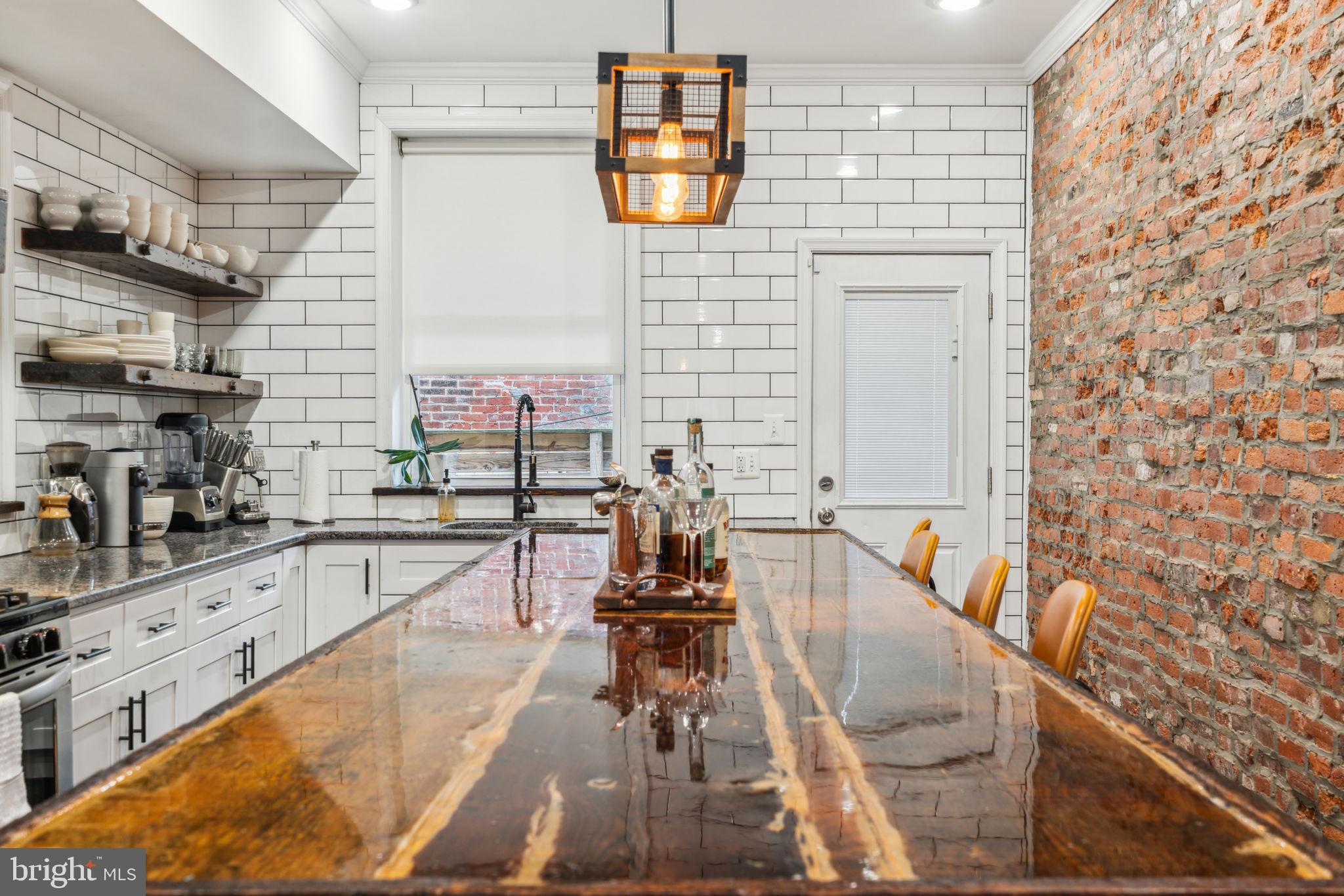 If you think you've seen a home like this before, look again! Craftsmanship and materials you'd expect to find in a home 3x the price. Stunning four-bedroom home with historic quality and charm, yet with all the comfort and convenience of like-new construction. The extensive remodel incorporates rare salvaged materials. Stepping through the front door, immediately notice the Brazilian walnut mixed-width hardwood floors, meticulous wainscotting, beautiful brick-finish accent wall, custom windows, recessed lighting, and crown molding. The hand-built open tread stairs feature wood reclaimed from Brewerytown's old milk depot, and the Victorian-era built-in was reconstructed to include a full-length coat closet. The kitchen island is the centerpiece, crafted from original timber from the home, hand-inlaid brass, set on antique wine barrels. Kitchen features five-burner gas range, hand-hewn shelving with vintage railroad spike hardware, shaker cabinets with soft-close, and reclaimed wood sills. Backsplash tile extends to ceiling. Upstairs, note the high ceilings, smooth finish drywall, recessed lights on dimmers, and the stunning hardwood carrying through every bedroom. The primary suite features electric fireplace, 100-yr old genuine barn door, roman blinds, south-facing bay window, and generous walk-in closet. The en suite bathroom is everything you would expect in a home with this degree of artistry and taste, with skylight, meticulous slate-tiled shower stall with frameless glass, turn-of-the-century clawfoot tub with waterfall and hand shower faucet. Completely finished basement with tile floor and many of the same design touches as upstairs; most notably, a custom wet-bar and full room-length bench seating make this an excellent room to entertain. Full laundry room downstairs, as is the fourth bedroom and third full bathroom, with a distinct style within the motifs of this cohesive home. Note the tankless water heater, newer HVAC, and other updated systems of the home. The sewer lateral was recently replaced under the street. Located just a few short blocks to East Fairmount, Smith playground, the Art Museum complex, boathouse row, and the renowned Schuylkill River Trail. Walking distance to groceries, coffee and bagel shops, neighborhood gastropubs and taprooms. Come see this exceptional one-of-a-kind home, and see how it proves the adage, “There is no craftsmanship without art!”