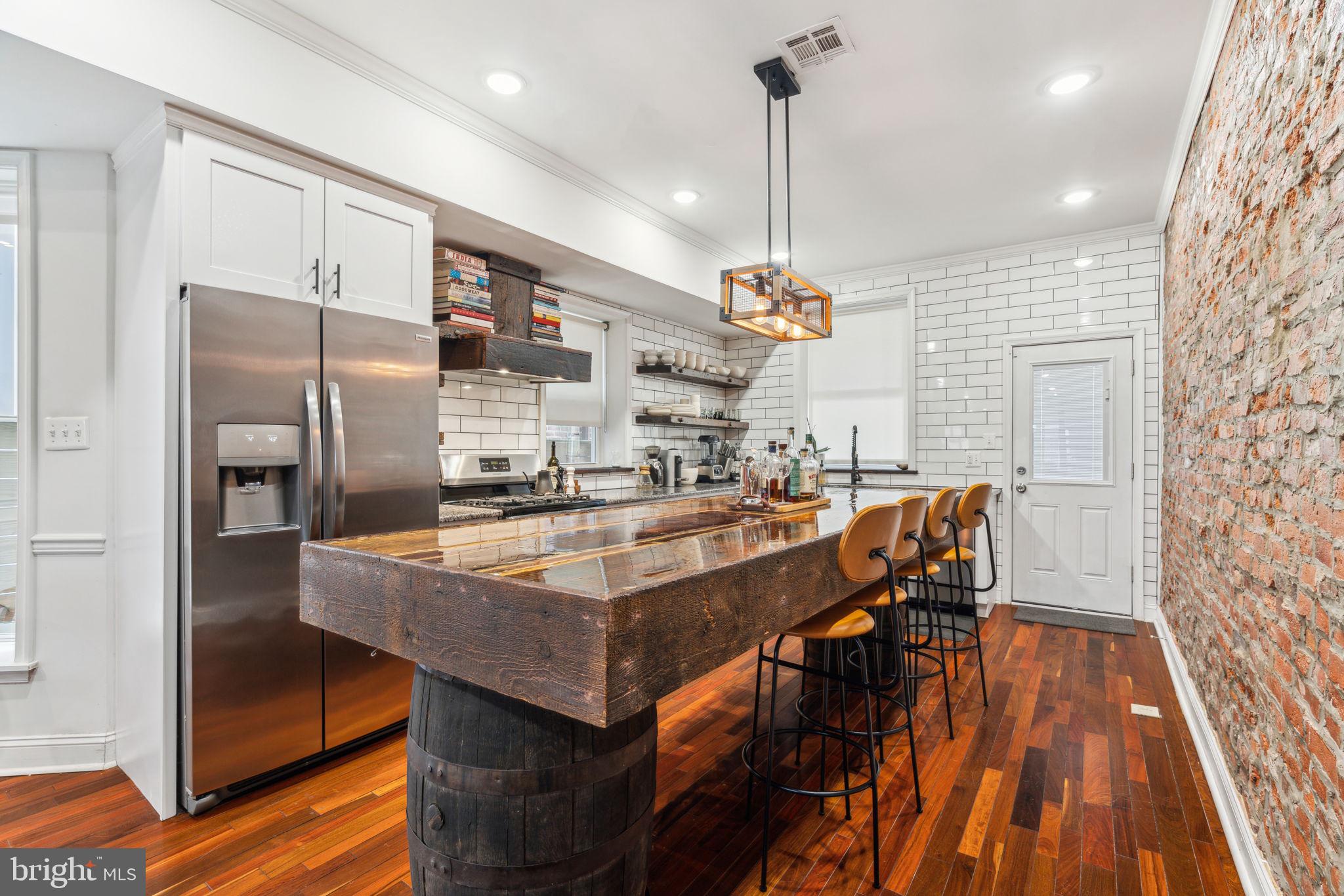 Brewerytown Best Buy! Sellers are motivated and committed to passing this home to its newest owners. Bonus: 4–5 years remaining on its tax abatement! If you think you've seen a home like this before, look again! Craftsmanship and materials you'd expect to find in a home 3x the price. Stunning four-bedroom home with historic quality and charm, yet with all the comfort and convenience of like-new construction. The extensive remodel incorporates rare salvaged materials. Stepping through the front door, immediately notice the Brazilian walnut mixed-width hardwood floors, meticulous wainscotting, beautiful brick-finish accent wall, custom windows, recessed lighting, and crown molding. The hand-built open tread stairs feature wood reclaimed from Brewerytown's old milk depot, and the Victorian-era built-in was reconstructed to include a full-length coat closet. The kitchen island is the centerpiece, crafted from original timber from the home, hand-inlaid brass, set on antique wine barrels. Kitchen features five-burner gas range, hand-hewn shelving with vintage railroad spike hardware, shaker cabinets with soft-close, and reclaimed wood sills. Backsplash tile extends to ceiling. Upstairs, note the high ceilings, smooth finish drywall, recessed lights on dimmers, and the stunning hardwood carrying through every bedroom. The primary suite features electric fireplace, 100-yr old genuine barn door, roman blinds, south-facing bay window, and generous walk-in closet. The en suite bathroom is everything you would expect in a home with this degree of artistry and taste, with skylight, meticulous slate-tiled shower stall with frameless glass, turn-of-the-century clawfoot tub with waterfall and hand shower faucet. Completely finished basement with tile floor and many of the same design touches as upstairs; most notably, a custom wet-bar and full room-length bench seating make this an excellent room to entertain. Full laundry room downstairs, as is the fourth bedroom and third full bathroom, with a distinct style within the motifs of this cohesive home. Note the tankless water heater, newer HVAC, and other updated systems of the home. The sewer lateral was recently replaced under the street. Located just a few short blocks to East Fairmount, Smith playground, the Art Museum complex, boathouse row, and the renowned Schuylkill River Trail. Walking distance to groceries, coffee and bagel shops, neighborhood gastropubs and taprooms. Come see this exceptional one-of-a-kind home, and see how it proves the adage, “There is no craftsmanship without art!”