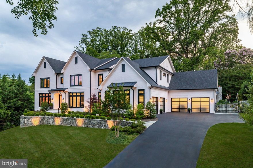 Hidden down a discreet private drive along one of McLean’s most iconic roads, 827 Dolley Madison Boulevard is a custom estate representing the highest caliber in design, materials, and craftsmanship. Constructed in 2021, the immaculate residence rises over its surroundings, its four sides of white brick with dark window trim creating an imperious presence that exudes transitional elegance, both timeless and modern.

A stone retaining wall sets the tone for a harmonious blend of extensive hardscaping and manicured landscaping, all radiantly illuminated after sunset to envelop the setting in a warm glow. A flagstone walkway gracefully leads to double glass front doors beneath a stately portico, opening to a sophisticated plan spanning more than 9,700 finished square feet. Interiors curated by Edith Gregson Design showcase sumptuous selections—Hoppe hardware, Visual Comfort lighting, and wall coverings by Schumacher, Phillip Jeffries, and Temperley London,all integrated with fastidious workmanship and an artful eye.

Formal living and dining rooms flank the reception hall. The living room offers wooded views and gleaming candy-gloss walls, while the dining room dazzles with a lacquered ceiling, Murano blown-glass chandelier, and bold millwork. At the center, an octagonal rotunda soars open to above, anchoring the home with graceful symmetry. A study lined with built-ins doubles as a bedroom suite with full bath. An elevator and powder room are set within the adjoining vestibule.

A grand central staircase, bathed in natural light, separates the informal spaces. The family room features a striking grasscloth coffered ceiling and floor-to-ceiling marble fireplace, opening to a screened porch for year-round enjoyment. The chef’s kitchen is a functional masterpiece, with stacked shaker cabinetry, industrial pendants, and a custom Coppersmith hood above a full Thermador suite. A waterfall peninsula transitions to a sunny breakfast room opening to the rear patio. An amenity-rich mudroom area includes a pantry, laundry, cubbies, a pool bath, and access to the four-car garage.

The primary suite occupies its own wing upstairs, boasting a tray-ceilinged bedroom, wet bar, and balcony. A custom beauty room doubles as a hidden office, while a bespoke dressing room offers dual-tone cabinetry and center island. Two additional walk-ins are each fully outfitted. The marble-clad bath impresses with arched ceiling above a Victoria + Albert tub and walk-in shower. Radiant floors, dual vanities, and dual water closets complete the space. Four additional bedrooms each feature tray ceilings, ensuite baths, and spacious closets. A secondary laundry completes this level.

The lower level, with 10-foot ceilings, is an entertainer’s dream. A walkout recreation room centers the space, with adjacent bar featuring antique mirrored backsplash and a lounge with riveted metal fireplace. Additional amenities include a screening room, fitness center, wine room, sixth bedroom suite, extra laundry, and stylish powder room. State-of-the-art systems include full Lutron lighting, surround sound, Vector security with video monitoring, and advanced HVAC and water treatment.

Outdoors, a bluestone terrace surrounds a 40' x 20' saltwater lap pool with automatic cover, water features, built-in seating, and dramatic lighting. The adjacent cabana features a roaring fireplace with TV above, lounge and dining areas, and a full outdoor kitchen. Beyond, stone tiers cascade to a cutting and herb garden framed by lush plantings.

Just a quarter mile from the GW Parkway, the estate enjoys one of McLean’s most coveted locations, convenient to both Washington and Tysons Corner. Amenity-rich, exquisitely appointed, and designed with impeccable taste, 827 Dolley Madison Boulevard stands as one of the Capital Region’s premier showcases of restrained elegance.