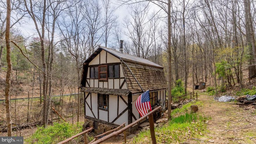 ABSOLUTELY ADORABLE AND AFFORDABLE RUSTIC COTTAGE IN THE WOODS. Perfect place to get away from it all and just unwind in peace and serenity. "The Gingerbread House" has been lovingly hand built and thoughtfully customized on13.2 acres, complete with stream and spring fed water source. Spring on neighboring property. Sold fully furnished. New queen mattress in loft. Has recently been rented as a successful and highly sought-after AIR BnB!. 10X12 shed/extra sleeping space. Outhouse for bathroom. Cabin has electricity, wood stove heat, and propane line into the cabin has been connected to small propane tank. The fastest WiFi offered by Frontier. Landline phone in place. Located near numerous fishing spots (rivers, streams, dams), national forest, and all the many lovely attractions of Pendleton and Highland counties. You must see the unique features and the potential in person! Truly, a little slice of heaven! DON'T MISS OUT ON THIS UNIQUE OPPORTUNITY TO OWN YOUR DREAM CABIN!