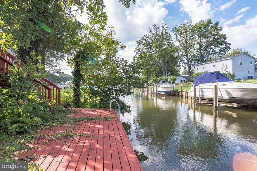 Welcome home to this charming WATERFRONT Cape Cod right on the edge of a deep canal leading to Middle River! You'll have plenty of space for you and your family with 3 bedrooms and 2 full bathrooms. Take the red wooden steps up to your enclosed front sunporch with ceiling fan that overlooks a well landscaped front yard with fruit trees! Light and bright living room features a side door exit, cooling ceiling fan, and hardwood floors that flow to the dining room. Entertain guests easily in the formal dining room with ceiling fan and French double door access to the upper level porch overlooking the canal. The spacious kitchen plenty of cabinet and counterspace, tile flooring, backsplash, and deep sink with detachable faucet and window view. Also features a breakfast bar with enough seating for 6 and a hanging pot rack. Enjoy everyday meals in the neighboring breakfast nook with ceiling fan! Full size bathroom with large vanity area completes the level. Two bedrooms on upper level both have charming attic ceilings and plush carpeting. Lower level (basement) features shiplap walls, plush carpeting, and a kitchenette, complete with cabinets, double door fridge and deep sink with window view. Relax in the main bedroom suite that features plush carpeting and easy access to the full size bathroom with double shower head. Walk out to the lowest level deck and enjoy the Canal views - steps away from your bedroom! The three level deck and back yard patio, with included patio furniture, is great for summer entertaining! Soak in the hot tub on the deck outside, and dock your boat at the 50 ft bulkhead. Two storage sheds will hold all of your aquatic belongings. Laundry room in basement features full size General Electric washer and dryer, plus a rinse sink, shelving, a second refrigerator and additional space for storage. Enjoy easy parking with two off street parking spots. Community beach is only $60 yearly! Near multiple shopping and dining destinations while still feeling like a getaway. Do not miss this one!