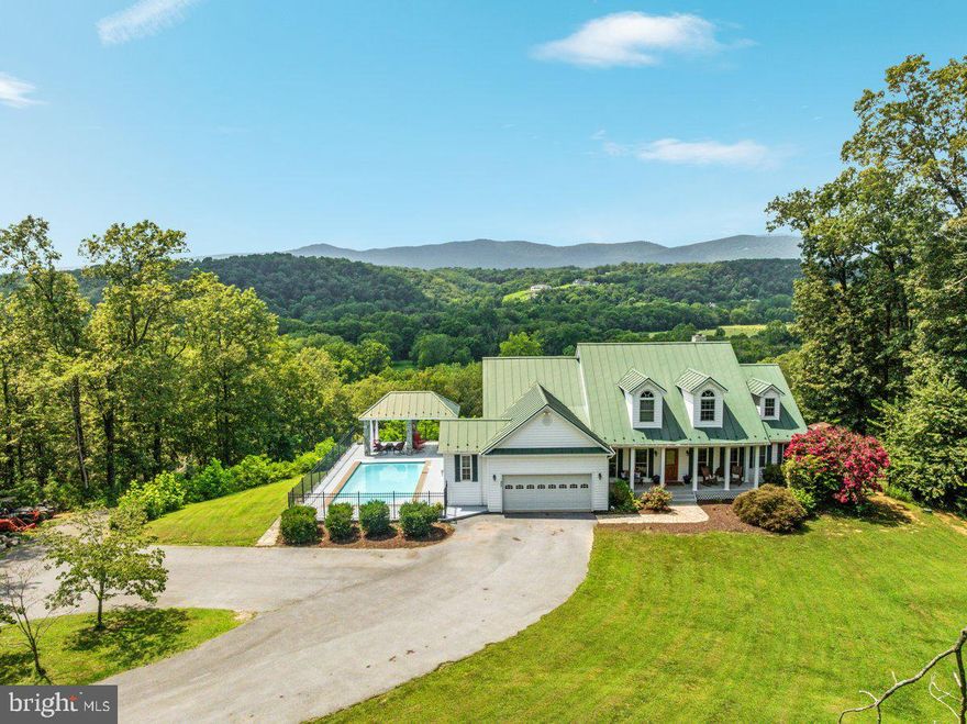 An Extraordinary Riverfront Estate | 22 Acres of Private Country Living

Welcome to an unparalleled sanctuary of luxury and tranquility—this 22-acre riverfront estate is a rare offering that blends natural splendor with elevated living. Set against a backdrop of panoramic mountain views and the serene flow of the river, this exceptional property promises the ultimate escape.

Designed for both indulgence and adventure, the estate features a heated saltwater pool, perfect for year-round entertaining and relaxation. Equestrian enthusiasts will appreciate the two-story, fully powered horse barn, along with three fenced pastures, each outfitted with water, electric, and run-ins. For outdoor lovers, enjoy a private hunting blind, 4-wheeler access, and an abundance of wildlife across your own private grounds.

The half-acre fenced dog run ensures pets roam freely in a secure space, while the expansive driveway accommodates over 15+ vehicles, ideal for hosting grand gatherings. A total of four garage bays—two attached, two detached—complete the estate’s unmatched functionality.

Step inside the light-filled residence, where soaring ceilings, walls of windows, and timeless finishes define the interior. The great room features a vaulted ceiling and marble fireplace Surround, setting the tone for the home’s warmth and elegance. The main-level primary suite is a private retreat, complete with its own fireplace and a spa-inspired en-suite bath offering dual vanities, soaking tub, and walk-in shower.

Upstairs, three guest suites share a full bath. The fully finished walkout lower level boasts a second full kitchen, full bath, and multiple living spaces—perfect for a guest suite, private retreat, or income-generating apartment with its own entrance.

This estate is built for comfort and peace of mind, with a recently upgraded geothermal HVAC system and a Generac whole-house generator to ensure uninterrupted living.

Just minutes from downtown Front Royal, Shenandoah National Park, and commuter routes, this property offers the rare combination of seclusion, sophistication, and convenience. Has road Maintenace agreement, and no other restrictions.

Luxury, lifestyle, and legacy—all in one exceptional riverfront estate.