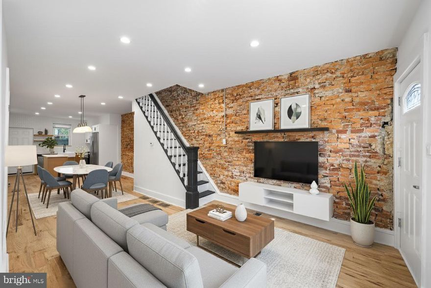 Welcome to 2115 Watkins St, a fully rehabbed 3-bedroom, 1.5-bath home in Point Breeze with a private patio, exposed brick character, and a modern, move-in ready interior. Step inside to an open main level with sanded and stained red oak hardwood floors, recessed lighting, and a full exposed brick feature wall with reclaimed wood shelving. The staircase, freshly restored with contrasting black-and-white detail, adds architectural charm. At the back, the kitchen blends warm wood lower cabinets with crisp white uppers, stainless steel appliances, a central island, and a sleek black hood. Open shelving, a tile backsplash, and matte black fixtures tie the look together. A half bath on this floor keeps things convenient. Upstairs, three bedrooms with hardwood floors and oversized windows offer natural light and versatility. The full bath is a showpiece, featuring a wood-look slatted accent wall, rainfall shower with matte black fixtures, a floating concrete-style vanity, and wide-plank tile flooring. The basement provides laundry and storage. while outside, a private patio extends the living space. Located near local favorites like Batter & Crumbs Café, On Point Bistro, Hardena, and DiSilvestro Playground, with easy access to Washington Ave, Broad Street, I-76, Center City, University City, and Graduate Hospital. Schedule your showing today.