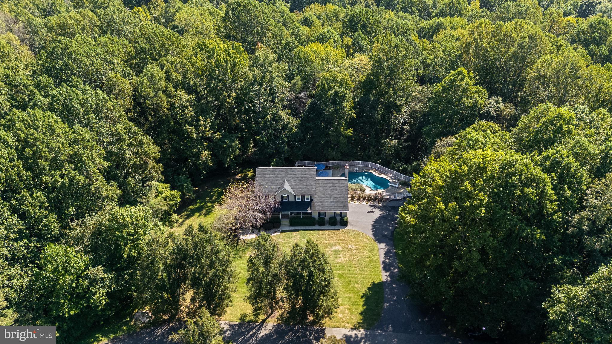Prepare to be captivated by the most stunning property available on the Huntingtown market! Tucked away on one of the most private lots in the coveted Wilburn Estates, this QBH home sits on 2 secluded acres and is the definition of DESIRABLE! A welcoming front porch sets the tone, leading into a grand two-story foyer with gorgeous wide-plank LVP flooring and fresh neutral paint throughout- ready to complement any style of furniture. The heart of the home is the brand-new kitchen, designed for both functionality and entertaining. A sprawling white quartz island seats up to seven, surrounded by all-new white cabinetry, a double Café oven, Bosch dishwasher, wine fridge, stainless steel appliances, custom wood hood, tile backsplash, and a massive pantry with wood shelving. The kitchen flows seamlessly into the great room, offering views of your private backyard oasis. Step outside to your expansive trex deck and down to your newly resurfaced inground PebbleSheen pool (lifetime warranty) - complete with a large patio with plenty of space for lounging and entertaining. Back inside, the formal dining and living room combo is perfect for gatherings, while the main-level office adds functionality for those that may work from home. Every room is accented with beautiful trim details. Upstairs, the dreamy primary suite boasts vaulted ceilings, a massive walk-in closet, and a spa-inspired bathroom featuring a freestanding soaking tub, double vanities, and a glass-enclosed shower with elegant 3x6 tile. The fully finished basement extends the living space with a second kitchen, 5th bedroom, full bath, a walkout to the fenced yard, and an impressive theater room. Even the garage shines with epoxy flooring. Additional updates add peace of mind: a 5-year-old roof and gutters, resurfaced pool, and countless “new” upgrades throughout. This is more than just a home - it’s your opportunity to live in one of Huntingtown’s most sought-after neighborhoods.