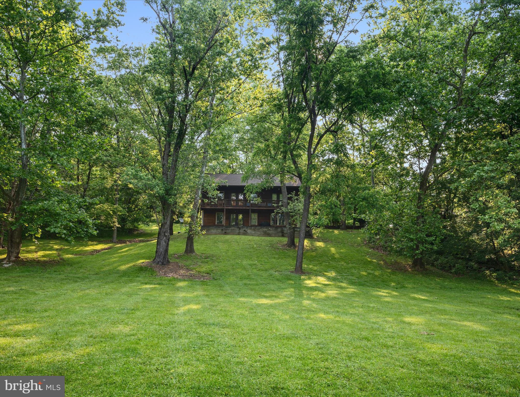 PRICE REDUCED! Welcome to your summer sanctuary on the Shenandoah River. With 205 feet of private river frontage and 1.367 acres with mature trees, this cedar-sided retreat in Harpers Ferry offers the perfect blend of seclusion, comfort, and outdoor adventure.
Wake up to the sound of the river and enjoy morning coffee on the double covered porches while mist rises from the water. With views of the Shenandoah from nearly every room in the house, you'll feel connected to the outdoors whether you're relaxing inside or out.
The open-concept main level invites easy, breezy living with an eat-in kitchen that flows into the living room, complete with fireplace and access to the upper porch. The primary suite also opens to the porch and features an en suite bath. A second bedroom and a full hall bath with soaking tub complete this level.
Downstairs, the walkout level is made for summer living—this is the entrance everyone uses after a day of tubing or kayaking, with direct access to the lower porch, backyard, and river beyond. This level also features a spacious family room, a third bedroom with river views, a hall bath, an office (currently used as a bedroom), and a laundry/utility room.
The oversized two-car garage offers plenty of space for storing tubes, kayaks, and all your water gear for long, lazy days on the Shenandoah. Whether you're dreaming of a peaceful weekend escape, a full-time retreat, or a potential short-term rental, 173 Riverside Drive delivers the ultimate riverfront lifestyle.