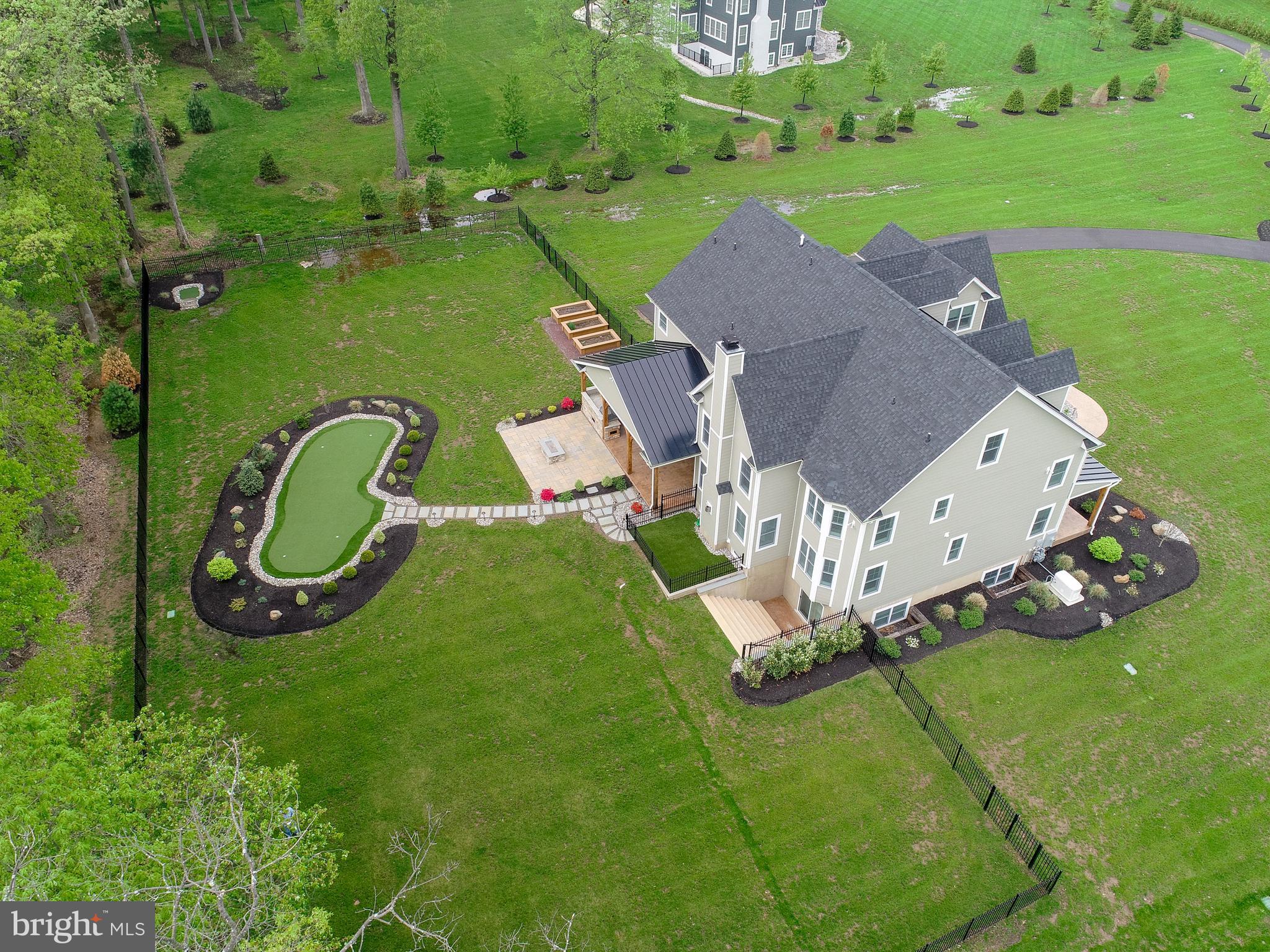 For the discerning buyer this home has been magnificently built only 1-1/2 years ago and highly customized. This turnkey home sits two beautiful acres, in a special enclave of 4 home sites. Attention to detail throughout including Hardie board and stone exterior with metal accent roofs and a covered front porch, side porch and back patio flanked by wood beams. The upscale fenced-in backyard is complete with Summer kitchen under the covered back patio, an extended patio for more seating with gas fire pit, a putting green, tee box and 3 garden beds. The property backs up to mature trees and another upscale neighborhood. The gourmet kitchen is rich and stunning from the upgraded cabinetry, stone countertops, extended kitchen island, professional grade, Monogram, appliances and a designer pantry, you'll fall in love. Some of the many special features include the interior barn doors, upgraded light fixtures, plumbing fixtures and recessed lighting throughout, plantation shutters on all windows, custom built-in bookcases with ladders in the living room and study, the dramatic floor to ceiling stone gas fireplace in family room, Sonos surround sound, Garage Tek system, Sapele Mahogany garage doors, and so much more. Stroll upstairs to find a special owner's suite complete with a beautiful owner's bedroom with vaulted ceilings, wood beams and a wonderous spa retreat as the owner's bathroom and the double glass door entrance into this stunning walk-in custom closet that will knock your socks off. Down the hallway are two additional bedrooms with en suites, one of which includes a sitting room (could be used as the 4th bedroom). The spacious & conveniently located laundry room comes with a laundry sink and an abundance of counterspace and cabinets. There is a walk-up to the 3rd floor attic that offers plenty of space to finish if desired. The walk-out, lower level includes a 4th bedroom with en suite along with an additional bonus room and a large unfinished area that could easily be finished for a multitude of uses. Enjoy a walking trail to neighboring community. Near the corner of Morris and North Wales Rds, your just minutes to Blue Bell Country Club, William Penn Inn, Skippack Historic District and easy access to Rts 202, 309 and PA Turnpike.