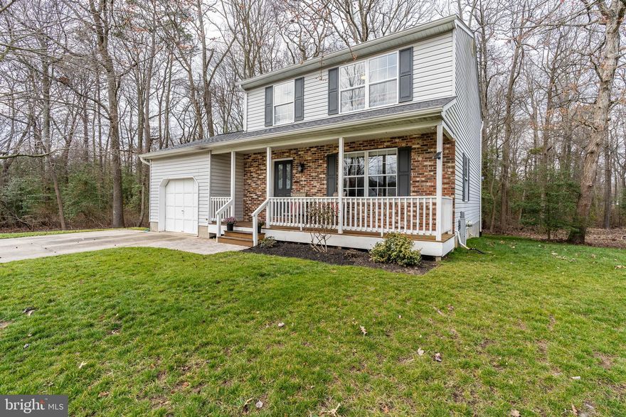 Beautiful colonial featuring 3 bedrooms, 2 full bath and 2 half baths.  Upgrades include a remodeled kitchen with stainless appliances, hardwood floors throughout the main level, fully finished lower level with 2 year new carpet and a wall-mounted tv that conveys.  The master bedroom has a large closet and en suite bath.  All plumbing replaced in 2016.  New roof in 2014 with a 10 year transferable warranty.  In addition to the lovely front porch, there is a large back deck with a wooded view that is perfect for entertaining or enjoying a quiet moment.  Finish it up with an attached garage and large parking pad, this home is Howard Manor living at its best.