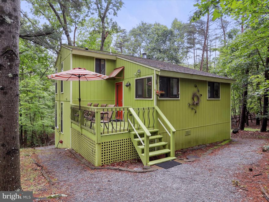 Charming Woodland Retreat at 184 Blizzard Lane.

***Now offered at a compelling new price — the perfect moment to make this retreat yours.

Nestled on 1.46 peaceful, wooded acres, this fully furnished 2-bedroom, 2.5-bathroom cottage offers the perfect blend of cozy charm and thoughtful design. Whether you’re seeking a relaxing weekend escape or a full-time sanctuary, this home delivers.

Step into the bright, eat-in kitchen with space for a generous dining table — ideal for hosting dinners, game nights, or morning coffee with a view. Just a few steps down, the sunken great room welcomes you with soaring windows and serene forest views. A ceiling fan and abundant natural light amplify the sense of space, while the layout invites conversation and connection.

The home features a unique split-floor plan offering privacy and comfort. The primary suite sits a few steps above the main living area and includes its own full bath. The second bedroom also has a private bathroom — perfect for guests or shared living.

A bonus room, formerly a screened-in porch, has been enclosed and transformed into a cozy and inviting space for gathering or relaxing. It also houses the laundry area and a convenient half bath. From here, a landing just outside the sliding door leads down to a screened-in porch, perfectly situated for peaceful moments and woodland views.

At $289,900, this inviting cottage comes with a Class B membership to The Woods, granting access to a wealth of amenities. Furnishings convey, making your move-in effortless.

This is more than a cottage — it’s a peaceful, personality-filled haven just waiting to be loved. Schedule your showing today.