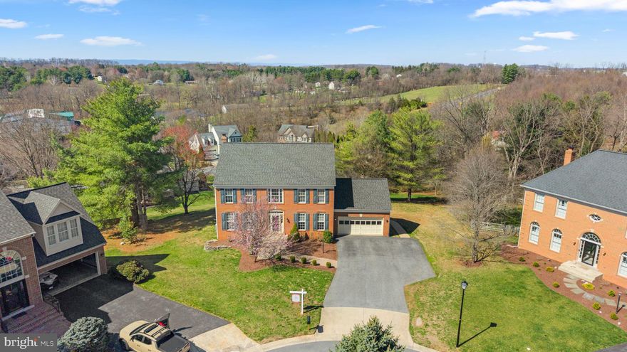 Beautiful brick-front colonial located on a quiet cul-de-sac. This spacious home offers 5 bedrooms, 3 full bathrooms, and 1 half bath. The large primary bedroom suite features cathedral ceilings, a spacious walk-in closet, and a large en-suite bathroom with cathedral ceilings. Updated kitchen and bathrooms enhance the home’s appeal, while custom moulding is featured throughout. A dramatic two-story entry foyer welcomes you inside, leading to a light-filled family room with a brick gas fireplace. Hardwood floors span the main level. Enjoy outdoor living on the deck with a large screened-in porch. The finished lower level includes a spacious recreation room with a gas fireplace and wet bar, a full bathroom, and a fifth bedroom—ideal for guests or extended living.