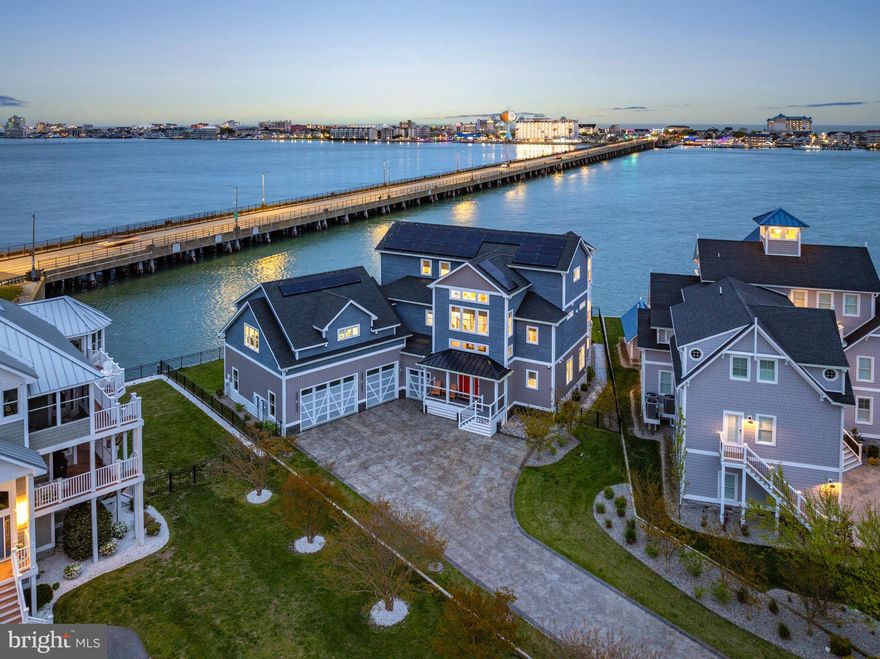 Tucked away in the gated Estates at Inlet Isle in West Ocean City, this beautiful custom-built waterfront home offers a relaxed coastal vibe with plenty of space to spread out. With five bedrooms and five-and-a-half baths including two expansive owner’s suites, each with its own private living area it’s perfectly designed for hosting guests while still giving everyone room and privacy. Step inside to an entertainer’s dream, featuring a spacious game room and a fully equipped in-home movie theater. The main living areas are open and inviting, centered around a high-end kitchen with premium finishes, an oversized island, custom cabinetry, and a butler's pantry that seamlessly blends style with everyday functionality. Built-ins and thoughtful architectural details carry the home’s modern coastal aesthetic throughout. This property also includes a massive three-car garage with a dedicated at-home gym, offering both convenience and flexibility for storage, fitness, and recreation. Outdoor living is truly exceptional, with multiple balconies and decks, a private heated saltwater pool, a hot tub just off the deck, and beautifully designed entertaining spaces ideal for both relaxing and gathering. Enjoy stunning bay and ocean views, along with breathtaking sunrise mornings and sunset evenings from nearly every angle of the home. Additional features include elevator access to all levels, a spa area, extensive hardscaping, an outdoor shower, custom exterior lighting, and advanced energy efficiency with a solar system and battery backup. Boating enthusiasts will love the private boat slip with lift, providing quick and easy access to the bay and open water. This home also offers the convenience of easy access in and out of Ocean City, allowing you to enjoy all the dining, shopping, and entertainment the area has to offer without sacrificing privacy. This is a rare opportunity to own a meticulously designed waterfront property in one of West Ocean City’s most exclusive communities.