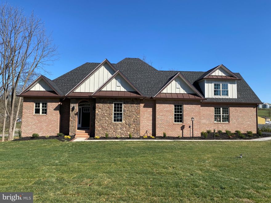 PRICE IMPROVEMENT! Home is completely done and ready for move in day! Welcome to this breathtaking brick and stone custom-built home, offering 4 spacious bedrooms and 3 and a half luxurious bathrooms. Nestled on almost 3 unrestricted acres, this property boasts an ideal blend of comfort, style, and practicality, with views of the surrounding mountains and pastures. The partially wooded lot ensures both privacy and scenic beauty, with plenty of space to enjoy your outdoor activities.
Step inside to find gorgeous Locust hardwood floors, crown molding, chair rail, recessed lighting, and attention to detail throughout. The gourmet kitchen features beautiful granite countertops, Samsung stainless steel appliances, tons of soft close Ivory cabinets, a large accent kitchen island, a huge pantry, and a kitchen sink instant hot water heater—perfect for quick meals and entertaining. The Great room is a showstopper.  With an 18-foot ceiling, a stone fireplace, wood beams and great natural light, this is sure to be your favorite spot in the house. Its inviting and cozy atmosphere is perfect for large gatherings or relaxing evenings.
The primary bedroom is a true retreat, offering a tray ceiling with built-in reading lights and direct access to the rear deck, perfect for enjoying your morning coffee or evening sunsets. The spa-like primary bath is equipped with tiled flooring, a walk-in tiled shower inclusive of a bench, niche and double shower faucets, and heated and lit mirrors adding a touch of elegance to your daily routine.
The split bedroom design is versatile and accommodating to many home buyers.  The two front bedrooms share a Jack and Jill full bathroom equipped with double sinks, tiled floors and a tiled tub shower.  In addition to the three main level bedrooms, there is a bonus room above the garage that serves as the 4th bedroom with a full bath, offering flexibility for any living arrangement. The oversized heated garage is a true standout, providing ample space for your vehicles and storage with 8' x 10' steel insulated garage doors and rear storage while the huge driveway accommodates up to 7 cars—ideal for hosting guests or storing multiple vehicles.  
The unfinished basement is a home of its own.  Full of possibilities and space for any hobbies, storage or an area to finish off. The full basement has 9-foot ceilings, a French door heading out to the stamped concrete patio and a rough-in for a future bathroom. Use the outdoor space for entertainment or simply enjoy your yard in style.
With no restrictions and a lot that is partially wooded, this home offers the perfect balance of peacefulness and tranquility. It gives you the freedom to personalize the property to your needs. The charm and functionality of this home truly make it one-of-a-kind. Schedule your tour today and discover all the exceptional details this home has to offer! Builders offering a $5,000 buyer's incentive...call to discuss!