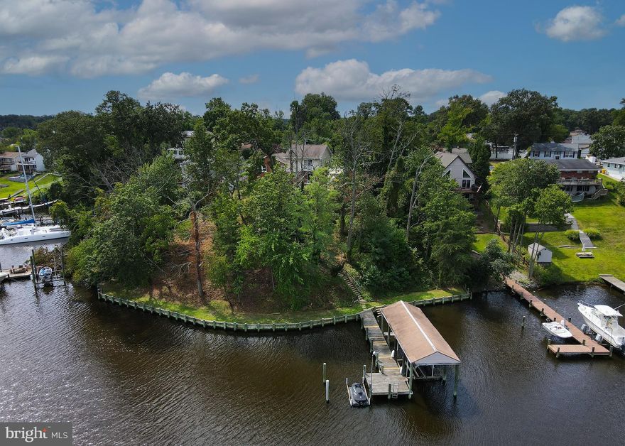BOATER' DREAM HOME!  (with EXTRA Building Lot included on Public Water/Public Sewer!) This Unique Waterfront property offers Expansive Water Views from nearly every window!  Situated on a .55 acre total parcel, the property features 176 feet of direct water frontage, a 63 ft long  L-shaped Pier with a 12,000lb electric lift and a Covered Boat House!  The low water mean is around 4-5' , so bring the boat and all the toys!
This 4 Level Split home of nearly 3,000 sq ft, features an HUGE 1,284 sq ft Addition, hosting a Luxurious Primary Bedroom with Vaulted Ceilings and a Private Balcony. What a great place to enjoy your morning coffee, overlooking the peace and serenity of the water! The addition also has a Spacious Full Bath with Soaking Tub & Separate Shower, (with Heated Floors!),  2 MASSIVE Walk-in Closets, PLUS Another large room, great for an Office/Den, or even a Nursery!  3 Additional Bedrooms and Another Full Bath on the 3rd level below.  The Main level (Kitchen, LR/DR) provides outdoor access to the large deck with built in Hot Tub.  On the finished Lower Level, level with the rear yard and plenty of natural light, you will find a Family Room w/ Fireplace, a Bar & Powder Room, with exits to the backyard for EVEN MORE outdoor living space! There's a perfect spot for a Firepit! There is also an attached 2 car garage and plenty of room for additional parking.  A outside parking pad near the garage is also heated! SO many possibilities- And you won't find anything else like this anywhere!  Keep the house and SELL the Extra Lot as a Future Investment??  Or keep it ALL to enjoy as your own "Grand Paradise"!!  Bring your Vision to make this THE HOME of your dreams! This is an Estate Sale: House is 100% livable,  however price reflects the need for updating and is being offered AS-IS only.