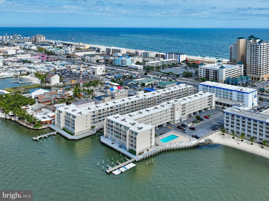 This beautifully updated Wight Bay condo offers the perfect blend of coastal charm, modern upgrades, and prime location. Nestled along the lagoon, this move-in-ready unit is just steps from the pool and a short distance to the beach, bay, and popular dining and entertainment spots, including Seacrets.
Inside, the tastefully decorated two-bedroom, two-bath condo features an open and airy layout with luxury vinyl plank flooring throughout (installed in 2023). Each bedroom includes a walk-in closet and an en suite bath, with both toilets newly replaced in 2024. The bright kitchen offers plenty of cabinet space, a pantry just outside of the kitchen, and an additional hall closet for extra storage. The dining area flows seamlessly into the living room, where sliding glass doors lead to the private balcony overlooking the tranquil lagoon. The primary suite also offers direct balcony access, perfect for enjoying morning coffee or evening sunsets.
Recent upgrades ensure peace of mind, including a Goodman HVAC system (2022, installed 2023), a Honeywell smart thermostat with WiFi, a GE washer and dryer (2023), fresh paint, new baseboard trim, and elegant crown molding in most rooms. The unit is plumbed and vented according to condo association rules, making laundry a breeze.
Wight Bay is packed with amenities, including a waterfront pool, fishing and crabbing areas, boat slips available for up to 22’ vessels, a grilling area, a private party room rental (Marlin Room), a pet relief area, bike and beach gear storage, and a laundry room. The community has also undergone major improvements, including new bulkheads, walkways (2024), roofs, and elevators in recent years, with stairwell renovations currently underway.
With no need to worry about furnishings—all furniture conveys (excluding some décor)—this condo is truly turn-key. Two parking spots per unit are available on a first-come, first-served basis. Plus, enjoy the shortest span from bay to beach in Ocean City! Don’t miss out on this incredible opportunity—schedule your showing today!