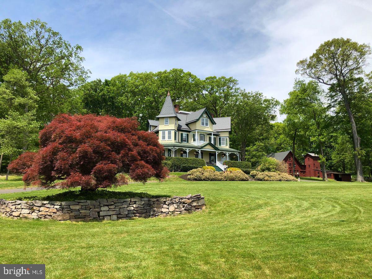This is not your great-grandmother's Victorian. A rare find, Wheelbarrow Hill is a superbly updated estate residence on 12+ acres showcasing exceptional craftsmanship and a full suite of renovations, making it a picture-perfect Bucks County property. Enjoy panoramic views from the wrap-around porch of this striking 1890 Victorian-era home tucked privately away within the property's bucolic acreage. The home includes expansive and well proportioned living and entertaining spaces, an exquisitely appointed owner's suite, luxurious baths and plenty of room for family and guests. The highest quality mechanicals were installed, including hydronic radiant heated oak flooring and a new synthetic slate roof. Write a novel or house guests in the charming one-bedroom cottage. The big red Bucks County barn contains soaring open spaces with workshops including a high-ceiling 22’ x 42’ space and a 2-car garage. Explore the other useful outbuildings. Play tennis, pickleball, and other games on the sports court. The landscape is gently rolling with mature trees, open land, and oh…the views. Forest conservation keeps property taxes astonishingly low. This property is conveniently located a few minutes from New Hope and Doylestown boroughs and is 40 minutes to Princeton, 60 minutes to Philadelphia, 90 minutes to NYC.
