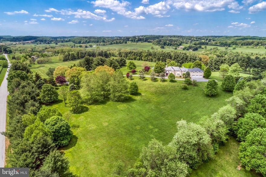 See RESIDENTIAL LISTING  MDBC488874 for additional photos and details. Inspired by English country architecture and situated in the heart of Maryland hunt country this warm and inviting home offers extraordinary panoramic vistas and remarkable pastoral views from every window. The elegant center hall with mahogany door and curved staircase is flanked by understated light-filled formal rooms and sophisticated casual spaces with high ceilings, quarter-sawn random plank oak hardwood flooring, and exquisite millwork throughout. The handsome gourmet kitchen features premium appliances, 6-burner gas range with griddle, expansive island, breakfast room, walk-in pantry, formal butlers pantry, and a mahogany writers desk facing long views of countryside. Highlights of the great room include the soaring cathedral ceiling with exposed beams, built-ins with entertainment center, and a magnificent floor-to-ceiling stacked stone wood burning fireplace extending to covered terrace with outdoor stone fireplace. The spacious main level master bedroom suite opens to second covered blue stone terrace for quiet respite. A finished basement offers second family room with wood burning fireplace, game room, fitness room, and full bath. Country-sized mud room for pets and lacrosse sticks. 8-stall stable includes office and dressage barn or second garage. Perennial gardens and gently manicured rolling lawn merge into pastureland and woodlands with riding trails providing diverse habitats for a multitude of native plants and animals. Nature abounds - witness bald eagles, red-tailed hawks, kingfishers, blue herons in flight. Enjoy the cacophony of peepers in near-by ponds on warm summer evenings, and seasons defined by wildlife who make the valley their home. Outdoor enthusiasts are drawn to the area known for steeplechase and equestrian events, horseback riding, biking, hiking, hunting, sporting clays and fly-fishing. Neighbors are committed to conservation and take pride in protecting open space and the rural and agricultural character of this renowned region. A unique and breathtaking property in a coveted and private location.