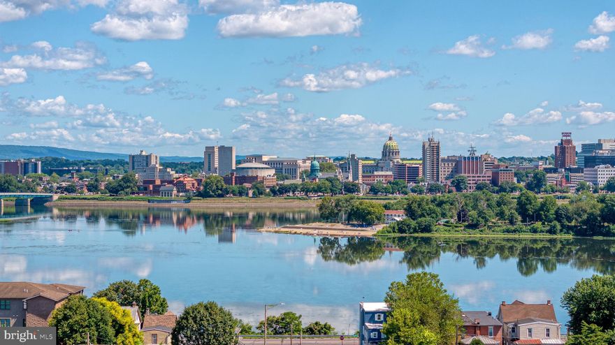 Experience unparalleled luxury living with breathtaking, million-dollar views of the Susquehanna River, iconic bridges, City Island, and the captivating Harrisburg skyline. This all-brick end-unit home combines timeless elegance with a carefree lifestyle in a private setting with no through traffic.
These highly coveted one-floor condos rarely come available in this neighborhood, offering 3885 square feet of luxurious one-floor living in Central Pennsylvania's prestigious maintenance-free community.
Enhanced with 2024 kitchen updates, the space features counters with a leathered finish granite and a massive island with quartz counters—perfect for entertaining and culinary enjoyment. The home also showcases the warmth and character of scraped Malbec walnut hardwood floors throughout. A stunning sunken living room features soaring 10-foot ceilings, and a dramatic stone fireplace flanked by built-in seating and shelving on each side. Triple crown molding throughout adds a refined, cohesive elegance to every room. The spacious family room is designed for entertaining, highlighted by three sets of French doors that open to the spectacular views and a custom-built wood bar with refrigerator, dishwasher, sink, and wine cabinet.
The expansive primary suite features a triple window with stunning views, direct access to the patio, and a luxurious bathroom with a double vanity, makeup area, expansive walk-in block shower, and two closets, providing both elegance and functionality. 
Each bedroom includes its own private bathroom, offering comfort and convenience for family and guests. The finished lower level extends your living space with two versatile rooms, a full bath, and a huge storage room with shelving. Plantation shutters throughout add timeless style and privacy.

The expansive brick patio extends your living outdoors, creating the perfect backdrop for gatherings or quiet moments while soaking in the panoramic scenery that will leave you in awe.

From sunrise to sunset, the views are nothing short of spectacular. This one-of-a-kind property presents an exceptional opportunity for those who value beauty, privacy, and convenience—all in one remarkable home.