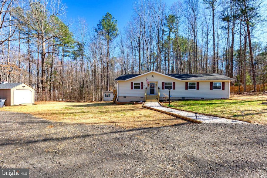 **Over $8,250 in improvements have been made to this home based on a previous inspections-it's now move-in ready and waiting for it's new owner.**  This charming country retreat offers the perfect blend of privacy and convenience, nestled on a serene 1.79-acre lot surrounded by trees. Set back from the road, atop a gentle incline, this home provides a peaceful escape with plenty of space for equipment, an RV, boats, and more. The seller, a contractor, has thoughtfully designed the property to accommodate all your outdoor needs while maintaining its secluded charm.  

Step up the newly installed front stairs and into the inviting family room, where a shiplap wall with a rough-hewn mantle,  cozy electric fireplace, and sunlit windows create a warm and welcoming atmosphere. From there, flow seamlessly into the spacious kitchen, perfect for entertaining with ample room for dining and wide sliding doors leading to a wraparound back deck, newly built in 2024. The kitchen is both stylish and efficient, featuring a dedicated coffee bar, a large pantry, stainless steel appliances, butcher block countertops, a built-in microwave, and a farmhouse-style sink overlooking the private backyard. A second entrance off the kitchen provides easy access to the deck and side yard, enhancing the home’s indoor-outdoor connection.  

The center hallway leads to three comfortable bedrooms and a full hall bathroom. The primary bedroom, tucked away at the back of the home, offers a tranquil retreat with tree-top views and an ensuite bathroom complete with a walk-in shower and linen closet. Throughout the home, updated windows fill each space with natural light, and every detail reflects the sellers’ dedication to maintenance and care.  

Outside, the property has been recently been treated with grass seed and straw, ensuring a lush green lawn come springtime. Raised flower beds line the front of the home, and a stone walkway adds to the home’s inviting curb appeal. Two sheds remain on the property, providing ample storage for tools and outdoor gear. Conveniently located just a short drive from Lake Anna, Spotsylvania High School, Dominion Raceway, shopping centers, hospitals, and the brand-new Kalahari water park, this home offers a perfect balance of peaceful country living with easy access to modern amenities. Come experience the charm and privacy of this hidden gem for yourself!