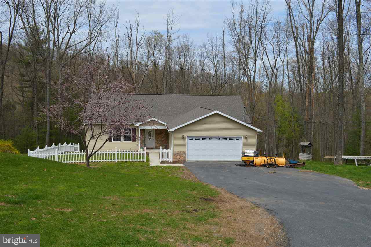 You can live in this spacious ranch style home the way that it is or you can greatly expand your living space into the walk up attic and exposed, walk out, daylight basement. Enjoy the wooded surroundings or watch wildlife from the enclosed, elevated deck or warm up by the fireplace in living room. Additional storage is available in the oversized attached 2 car garage. Room to roam and then some!