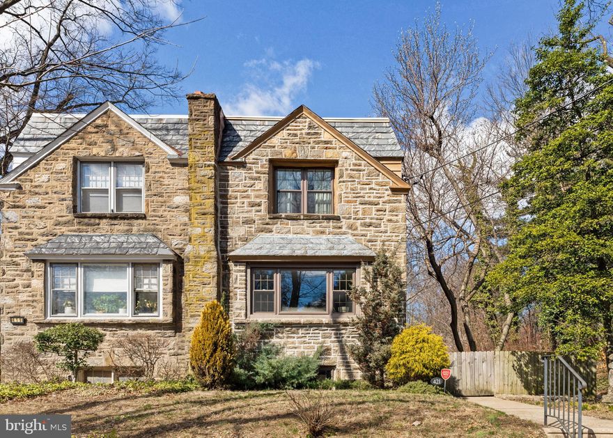 Welcome to this beautifully updated Wissahickon Schist twin in the heart of East Mt. Airy. Enjoy the benefit of natural light on three sides of this 3 bedroom 2 full bath and 2 half bathroom home. Inside, you'll find rich wood floors throughout and a thoughtfully designed open-concept kitchen and dining area. The stylish kitchen features modern appliances, floating shelves, and a sliding door leading out to a spacious deck, ideal for grilling and outdoor dining. A convenient half bath off the front living room adds extra functionality to the main level. Upstairs, the primary suite boasts its own en-suite bathroom, while two additional spacious bedrooms share a stylish hall bath. Custom closets have been installed in all three closets, with the primary bedroom featuring a full-wall closet system. The finished basement provides additional living space with the added convenience of a half bathroom on this floor as well. Adjacent to the finished space, there is a separate storage/pantry area and an area with laundry and utilities. Through the laundry area outside you’ll find access to the garage and driveway. The array of versatile outdoor spaces is truly special. The elevated back deck, just off the kitchen, is perfect for grilling and dining al fresco. The spacious fenced-in backyard offers room for playing, gardening, and unwinding. A more intimate side yard and side deck provide a cozy retreat for morning coffee or quiet relaxation, adding to the home’s charm and versatility. Enjoy peace of mind knowing this home was fully updated in 2017. Plus, the location is unbeatable—just steps from the train station for an easy commute and a short walk to the library, shopping, and restaurants on Germantown Avenue.