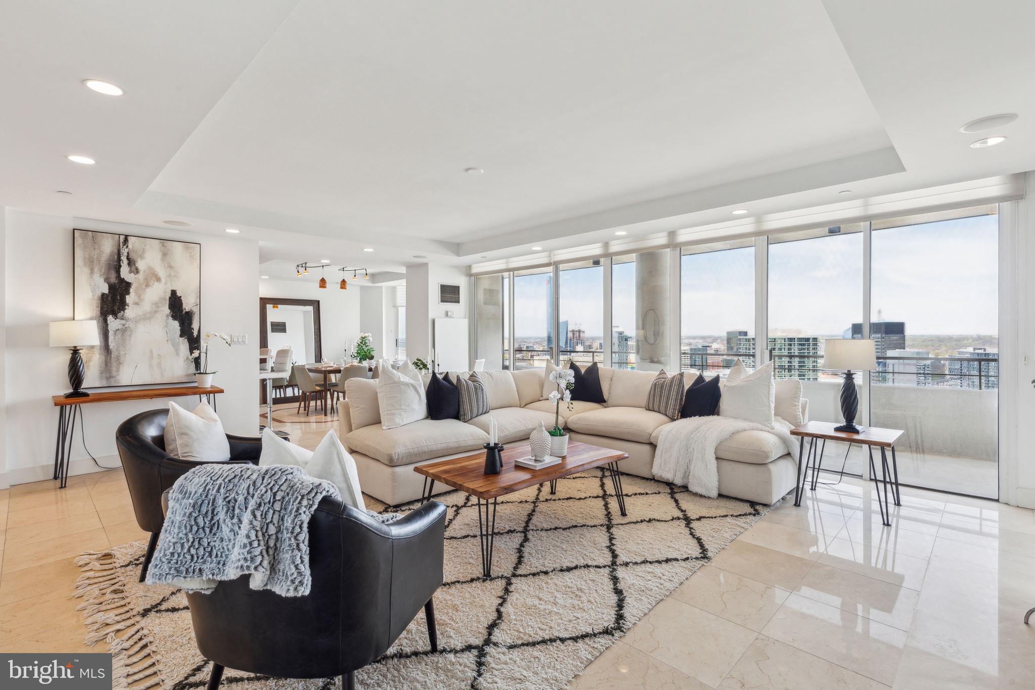 Beautifully appointed two bedroom penthouse with 270° sunset city views at the highly coveted Residences at The Rittenhouse Hotel. This gorgeous home features superb entertaining space, high-end finishes throughout, and a large private terrace with breathtaking western views. Enter through the grand foyer into the expansive great room with a wall of floor-to-ceiling windows, open living room, separate formal dining space and beautifully appointed kitchen. The living room features custom built-in display shelving and storage, fireplace with marble surround, marble tile floors, and incredible natural light. Open to the living room is a separate formal dining area with custom marble floor inlay, space to fit an eight-person table, and access to the large private terrace with panoramic western sunset views, perfect for entertaining. Adjacent is the updated chef's kitchen with flat dark wood cabinetry, marble countertops, designer tile backsplash, stainless steel sink with instant hot water faucet and garbage disposal, breakfast bar, and high-end stainless steel appliances including a Wolf oven and range with hood, built-in Wolf microwave, wood paneled Sub Zero fridge, and wood paneled Bosch dishwasher. Off of the foyer is the conveniently located powder room, appointed in marble. The incredibly spacious primary suite boasts more oversized windows, a cozy sitting area, access to the private terrace, two large custom-built walk-in closets with dark wood shelving and drawers, and a spa-like ensuite bathroom. The primary bathroom offers a dark wood double vanity with marble top, marble tiled Bain Ultra soaking tub, glass-enclosed walk-in shower with designer marble tilework, built-in linen storage, and tile floor. The second bedroom is generously sized and enjoys more oversized windows, built-in desk and shelf, large walk-in closet, and a full hallway bathroom appointed in marble with a large single vanity and glass enclosed walk-in shower. Adjacent to the hall bathroom is a laundry closet with stacked washer and dryer. Additional home highlights include fresh paint throughout, brand new carpet in the primary bedroom, recessed lighting and custom light fixtures, and excellent closet and storage space throughout. The condominiums at The Rittenhouse sit atop the five-diamond Rittenhouse Hotel. Residents of The Rittenhouse enjoy the use of a chauffeur-driven town car, concierge, and 24-hour lobby attendant. And for an additional fee they can enjoy the same amenities as hotel guests, including valet parking, housekeeping services, room service, spa and fitness center, indoor pool, dog walking, the newly renovated Paul Labrecque Salon, and Lacroix Restaurant.
