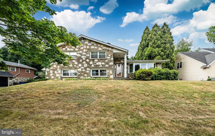 Colonial Stone 4 level Split located on a cul-de-sac.  4 spacious Bedroom. 2 Full baths. Tile Foyer opens to large living room with vaulted ceilings.  A huge picture window brings in natural light. Formal dining room. Large kitchen with breakfast area that opens to a patio.  Upper Level:  Primary Bedroom with en suite bathroom. Walk in closet. Sliding glass doors to an upper private balcony overlooking the backyard. Perfect place to unwind. 3 additional Bedrooms and Guest bathroom . First Lower Level:  Great Room wood burning fireplace and a  built-in Bar. Laundry room and half bath. Entrance to the  2 car garage. Lower level two:  Game room, gym, home office, you decide. Over a 1,000 extra square feet.  Located in the  West Mt. Airy section. Close to Park trails. Close to the train to Center City.  Hardwood floors under carpet. Come make this house yours. Built by the owner. Ready for the next owner to enjoy.