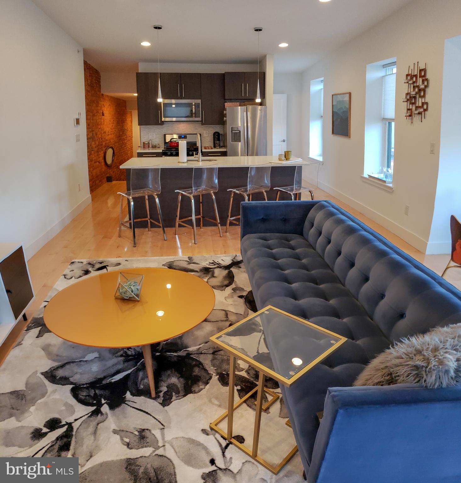 Enter into this beautifully designed 3rd floor condo flat with keyless entry! Impeccable views and natural light pouring in at every window. Enter with warm exposed brick walls flowing right into the kitchen/ living room. Enjoy breakfast by the bay window or entertain at the bar. The middle bedroom has its own full bath and walk in closet, with modern ceiling fan. Down the hall you'll pass the laundry and storage. At the end enjoy the master suite with custom closet organizer and spacious bathroom! Just up the stairs you'll love the large shared roof deck!!!