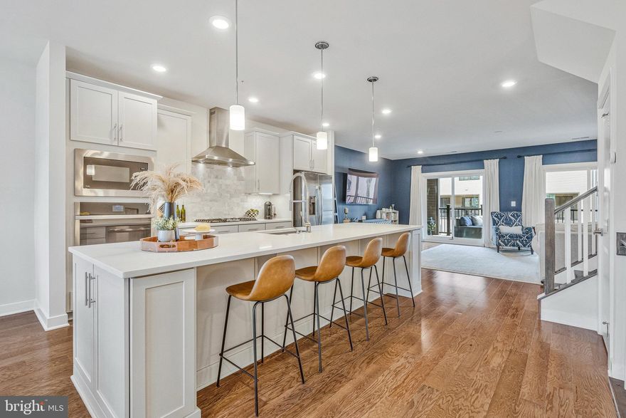 Welcome to this beautifully maintained Picasso model by NV Homes, offering 3 bedrooms, 2.5 baths, and an attached one-car garage plus additional driveway parking. This exceptional home shows like new! The main level features a bright, open layout anchored by a stunning gourmet kitchen with a spacious seating island, quartz countertops, elegant marble backsplash, stainless steel appliances, and white soft-close cabinetry. Recessed and pendant lighting paired with wide-plank hardwood flooring enhance the refined feel throughout the main level. The addition of plantation shutters enhances the home with a timeless designer look. A separate dining area provides space for formal meals, while the generous family room extends to a private enclosed balcony with a gas fireplace—perfect for year-round enjoyment.  Upstairs, the spacious primary suite features a tray ceiling, sitting area, two walk-in closets, and a well-appointed bath with dual vanities and a large glass shower with dual showerheads. Convenience continues with a spacious upper-level laundry room with counters and cabinet space. The hall bath has dual vanities and a tub/shower combo. The garage is fully finished and includes shelving for additional storage.  Amazing location ideally situated close to the Herndon-Monroe and Innovation Center Metro Stations, Dulles Toll Road, Route 28, Fairfax County Parkway, Dulles Airport, Worldgate, and Reston Town Center. Short walk to Amazon Web Services. Shops and restaurants are just moments away, and the community provides ample guest parking.
***NOTE: GPS will take you to the REAR of the home,  take the short walk around the building to the front door- right by the playground! PARKING: there is guest parking, but you may also park across the street at Montessori School on the weekend.