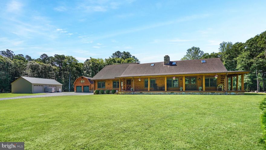 Nestled in the heart of rural Pocomoke City, sits a stunning log cabin, boasting breathtaking views across over 36 sprawling acres. Imbued with a timeless elegance and the utmost luxury, this property represents a rare opportunity to own a slice of paradise in one of Maryland's most sought-after locations.
Comprising 3 spacious bedrooms+ office/flex room and 2 ½ baths, this home seamlessly blends rustic charm with modern amenities. You'll love the large covered front porch that welcomes you upon arrival, inviting you into an open concept living room, complete with a beautiful stone fireplace with pellet stove. In the kitchen you will find an island, gleaming stainless-steel appliances, and a double oven, perfect for hosting intimate dinners or grand feasts. The dining area caters to all occasions, while vaulted ceilings and a family room with a pellet stove create an ideal space to relax and unwind.
The primary bedroom suite includes double vanities and an upgraded shower, providing the ultimate retreat after a long day, along with an impressive walk-in closet. An enormous, covered deck offers great space for relaxing or entertaining. 
There is a 3-bay attached garage with Yoder wireless garage doors, the household mechanicals,  and a walkup loft for storage. Outside you will find an impressive detached garage with split system and loft. The loft is spacious, with mini splits, and a large balcony overlooking the pond and grounds. Perfect for guests or an additional office space.  You will be wowed with the 40 x 60 pole barn, that offers ample space for storage or hobbies. This building is wired for your RV and all of your toys that need extra amperage.
The property features a pond and over 24 wooded acres, ideal for hunting or 4-wheeling. Several deer blinds and stands are already in place for the upcoming season. The property also includes a backup generator, central vacuum, and 2 Rinnai water heaters.  With Fiber internet installed, the house and outbuildings benefit from wireless internet throughout! 
Without a doubt, this log cabin in Pocomoke City provides the ultimate rural retreat, complete with luxurious finishes and all the modern amenities you could want or need. With so much to love about this beautifully crafted property, it's time to make your dreams become a reality.