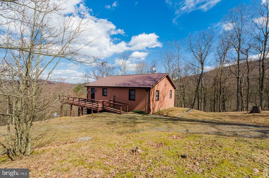 Watch for the eagles! This 2 bedroom 1 & 1/2 bath cabin has a wrap around deck  for taking in the view and spotting those eagles. With deeded Cacapon River access this one has it all. Over 8 acres, Cathedral ceilings, hickory cabinets, hardwood floors and mostly finished walkout basement. Come out and take a look!