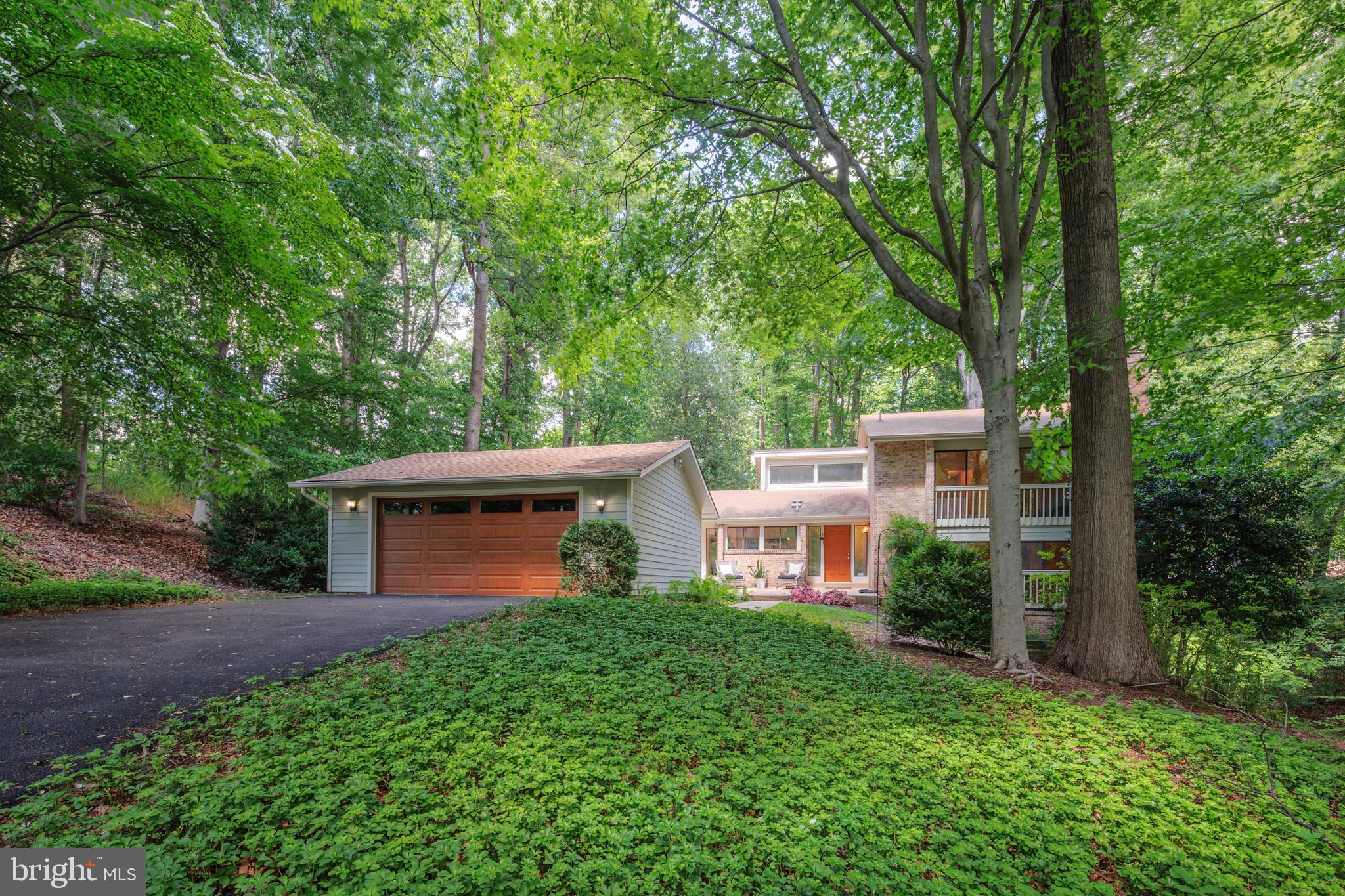 Tucked at the end of a cul-de-sac, 6921 Carlynn Court offers a rare blend of contemporary architecture and natural serenity on a lush, wooded acre in the heart of Congressional Country Club Estates. Featuring 4500 finished square feet this six-bedroom, four-bath residence is thoughtfully designed to capture abundant natural light and deliver effortless flow across its elegant living spaces.
Dramatic vaulted ceilings accentuate the main living areas—kitchen, dining, and living rooms—while expansive windows frame tranquil views of the surrounding landscape. Rich hardwood floors run throughout the main levels of the home, complementing its clean lines and modern finishes.
A dedicated home office, multiple living rooms, an expansive lower level that offers tremendous versatility with an in-law suite, two separately spaced finished areas of flex space and multiple storage areas.
Enjoy the best of Bethesda living—just minutes from downtown, schools, shopping, dining, and major commuter routes—all while being tucked away in one of the area's most coveted neighborhoods.