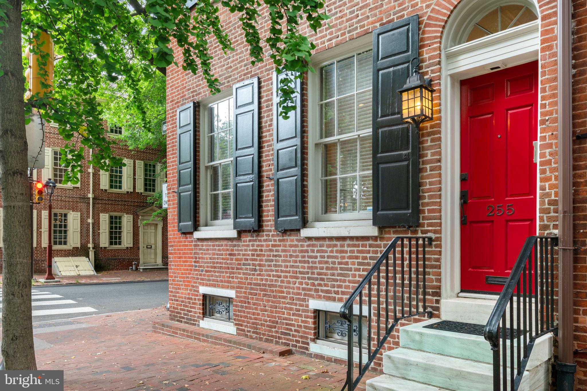 Built in the mid-1700s, the rich history of this property will captivate even the most enthusiastic historian. During the American Revolution, prominent figures such as George Washington, Alexander Hamilton, Thomas Jefferson, Benjamin Franklin, and John Adams frequented 255 Pine Street to pay Governor Thomas McKean countless visits. Meticulous and thoughtful updates have transported the property into the modern day while holding onto its enchanting historical charm. Enter the stately home and you are greeted with 12 ft. trey ceilings, an abundance of natural light, a beautiful marble-surround wood burning fireplace, and rich wide plank pine floors. The 20 ft. wide corner property allows for a spacious open floor plan and windows on 3 sides promising abundant light. The dining room, large enough to accommodate a substantial gathering, is finished off with a spectacular chandelier that matches another in the living room, with both included in the sale. The renovated kitchen is complete with Wolf and Sub Zero appliances, custom cabinetry a marble breakfast bar that fits up to 4 stools and is complemented with a marble backsplash and limestone floors. There are pocket doors to allow the kitchen to be closed off or open to the living and dining spaces. The large window by the sink overlooks the beautiful back patio with two gardens, one of which has a sprawling hydrangea bush. The kitchen's welcome center, with built-in bench and hooks, provides a spacious entrance to the home from the garden or after parking in the private garage. This level also has a convenient powder room with lovely herringbone stone floors, a spacious and well organized coat closet, and is wired for surround sound and alarm system. Go up the second floor to find more high ceilings and the grand study with built-in desk, bookshelves, and cabinetry. This is the perfect place to work from home, with an attached deck providing a relaxing ambiance for the workday. On the same level, the breathtaking master suite houses a huge walk-in closet and ample room for a king-size sleeping arrangement with accompanying furniture. The updated master bathroom features gorgeous marble shower and marble topped double vanity. The third floor hosts a large bedroom suite with vaulted ceilings that can easily be converted into 2 bedrooms to make this a 4-bedroom home. This level has 8 spacious closets yes, 8! The lovely bathroom has a double vanity, glass enclosed shower, and jacuzzi tub. On the fourth floor you will find the third spacious bedroom suite with a full bathroom and another wood burning fireplace. The basement is home to the laundry, lots of additional storage, and an unbeatable wine cellar equipped with a separate split system for cooling and humidifying that is the ideal environment for almost 3,000 bottles of wine. This home really has it all: over 3,500 square feet, corner property with windows on 3 sides, dual-zone HVAC, garage parking, 2 outdoor spaces, large open rooms with lofty ceilings, an incredible amount of closets and storage space, as well as the fascinating history with all the modern amenities for the most discerning buyer.