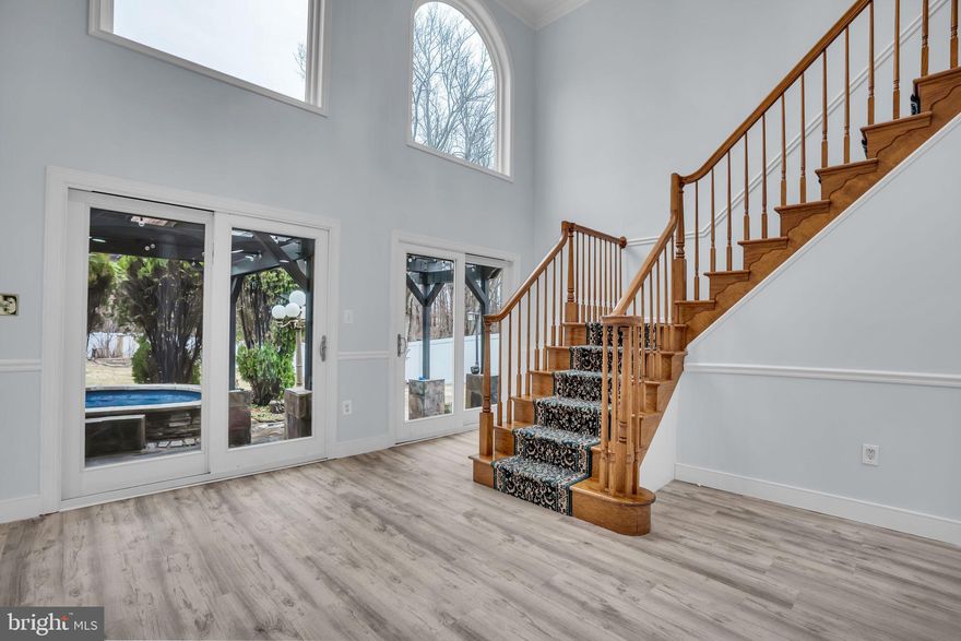 ***MAJOR $52K PRICE IMPROVEMENT! *** Discover unparalleled scale and quality in this stunning, turnkey Ravensworth Grove residence, boasting approximately 4,438 square feet of sun-drenched living space on a nearly half-acre lot (2 parcels). Perfectly designed for multi-generational living, this six-bedroom, six-bathroom home features three en-suite bedrooms—with options on both levels—and a premium two-story extension (completed 2002) characterized by rich millwork and three massive Palladian windows (replaced in 2024) w/ custom remote controlled solar blinds (2024). This meticulously maintained property offers long-term peace of mind with newer siding and gutters (2020), newer roof (2024), a reliable HVAC system (lower level system & 2 exterior compressors 2015; upper level system 2019), and a fully enclosed backyard featuring new vinyl privacy fencing (2024). The grand main level features elegant hardwoods and a gourmet kitchen that flows into a unique enclosed cooking balcony with a dedicated exhaust fan, while the bright, walk-out lower level serves as a secondary retreat with luxury vinyl floors and a massive recreation room with a wood-burning fireplace. Your private outdoor oasis is anchored by a custom concrete patio (2019) and a tranquil koi pond with waterfalls (2021), surrounded by mature fruit trees, a vegetable garden, and a tool shed. Modern amenities abound, including a large concrete driveway with an EV charger, all situated just minutes from Mosaic District, NVCC, George Mason University, Tysons Corner, and Washington D.C.   Short walk to neighborhood grocery store, restaurants, boba tea shop, medical offices. ***Check out this walkthrough video of the property: https://youtu.be/suPEPTnOdBQ