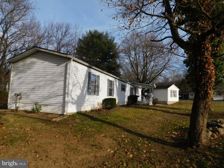 CHARMING single wide mobile home on a semi wooded spacious corner lot. Inside the home you will find an open and practical living room space with a propane fireplace for chilly winter evenings. The eat in kitchen has plenty of counter top space for meal prep and cabinets for storage needs. Have your morning coffee or read a good book on the front porch with views of the mountain or in the heated rear sunroom overlooking the stream.  Sunroom can also be a 3rd bedroom or office space. Large owners bedroom suite with adjoining bathroom and soaking tub. New LVP flooring was recently installed and walls have been freshly painted.  Enjoy the soothing sounds of a flowing stream from the patio in the rear yard.  A carport shelters two vehicles while the detached shed provides a workspace or storage for lawn tools and equipment. Public water and sewer.