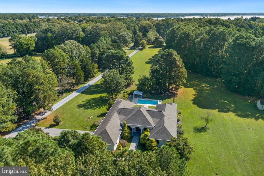 Welcome to Saint Michaels Retreat—an extraordinary 6-acre property overlooking the Links at Perry Cabin Golf Course with direct water access to Long Haul Creek and the Miles River. Just minutes from downtown Saint Michaels, this stunningly renovated residence offers over 4,100 sq. ft. of one-level living, thoughtfully designed for effortless indoor and outdoor entertaining. Inside, expansive living and dining areas feature 12-foot ceilings and abundant light. The custom kitchen and family room with gas fireplace anchor the home, while the welcoming foyer, formal living/dining rooms, and serene primary suite—with walk-in closet, built-ins, and a spa-like bath—all open to sweeping views of the pool, patio, and gardens. The gourmet kitchen showcases an oversized island with farm sink, walk-in pantry, wine cooler, extensive cabinetry, and top-of-the-line appliances, creating the perfect setting for both everyday living and memorable gatherings. Three additional bedrooms are well-appointed and share a spacious full hall bath. A private office with additional storage provides a quiet retreat for work or study. A mudroom with custom cabinetry and cedar closet, laundry room with new washer/dryer and utility sink, powder room, and a three-car garage provide both comfort and convenience. Renovated inside and out, the home highlights new flooring, upgraded fixtures and lighting, high-efficiency HVAC and water heater, and large Andersen windows that bathe each room in light. Outdoor living is equally inviting with a gunite pool (new filter and pump), expansive covered patio, pergola, paver-lined walkways, and a pool closet, plus a large shed for extra storage. A full bath just off the family room provides easy access to the pool area. Mature landscaping, a double-access driveway, and private pier (perfect for kayaking or paddle-boarding) complete the property. This remarkable home invites you to embrace the Eastern Shore lifestyle and all the beauty it has to offer. *A list of improvements is available in documents.