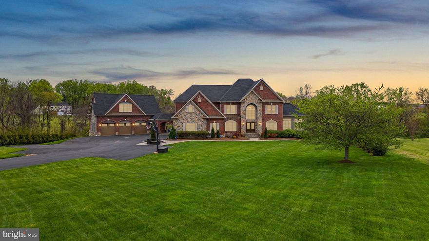 Welcome to this exquisite custom stone and brick estate, gracefully set on 5.71 acres of beautifully landscaped grounds. Formerly a model home, this residence is a showcase of timeless design, meticulous craftsmanship, and luxurious upgrades throughout.

Enter a dramatic two-story foyer with newly installed distressed maple hardwoods, intricate trim, and elegant tray/coffered ceilings. French doors open to a richly appointed main level study with custom cherry-built ins. A sun-drenched morning room offers sweeping views of the property, while the two-story family room impresses with floor-to-ceiling windows, a coffered ceiling, and a stacked-stone fireplace flanked by custom cabinetry. The gourmet kitchen is a chef’s dream with a massive island, maple cabinetry, premium Wolf, Viking, and Sub-Zero appliances, heated travertine flooring, and a bay window breakfast area that leads to a low-maintenance deck ideal for outdoor dining and entertaining.

The upper level offers a luxurious owner’s suite featuring a tray ceiling, sitting room, spa-inspired bath with extended vanity, temperature-controlled hot tub, and a custom walk-in closet with private laundry. All secondary bedrooms include walk-in or double closets and updated en-suite baths with custom stone tile, modern fixtures, and maple cabinetry. All closets were upgraded with California Closet systems.

The fully finished lower level is made for entertaining — featuring four French doors leading to a stunning paver patio, a full granite wet bar with Sub-Zero wine fridge, a gym, two additional bedrooms, and a spa-style full bath with an oversized steam shower.

For car enthusiasts and guests, the property includes an attached 3-car garage and a breezeway leading to a detached 3-car garage with a fully equipped in-law suite above, complete with kitchenette, full bath, and spacious living/sleeping area.

Step into your own private resort: a heated saltwater pool and spa, extensive stone hardscaping, pavilion-covered patio with outdoor fireplace, putting green, beach-style lounge with tiki bar, outdoor TVs, an additional fire-pit, and a separately fenced garden with dedicated irrigation zone. A long driveway offers extended parking and adds privacy.

Recent updates include: new architectural shingle roof, new interior paint and flooring, fully renovated pool with new coping, tile, and stone, refreshed patios and retaining walls, three mini-split systems (in garages and owner’s closet), newer A/Cs and water heaters, an automatic irrigation system,  and a full-house camera and sound system.  All Bathrooms and Kitchens have been updated, and there is a new state-of-the-art whole-house water system and the roof was updated in 2023!

This rare and remarkable estate blends luxury, lifestyle, and functionality in perfect harmony. A must-see!