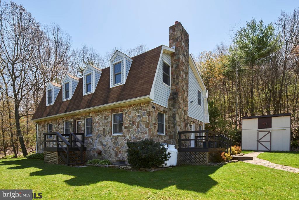 Natural Stone 2-story perfectly positioned on 2.74 serene & private wooded acres with a detached 2 car garage. This lovingly maintained & updated home delivers an open concept & spacious floorplan. The chef envy kitchen boasts stainless appliances, plenty of cabinets & ample countertop space for meal prep. Delightful dining room, large living room & a cozy 1st-floor den w/glass French doors. Handy 1st-floor laundry/mudroom & a full bath. Upstairs you will find 4 bedrooms & 2 bathrooms including the generously sized master suite with a recently remodeled private bath featuring a new vanity, light fixtures, faucets & tile floor. Finished basement boasts a family room, half bath, workshop & plenty of room for storage. This home features propane forced air heat as well as electric baseboard, wood stove & central air. Additional highlights include freshly painted interior, new luxury vinyl plank flooring in the kitchen, dining room & staircase plus a relaxing screened-in side porch.