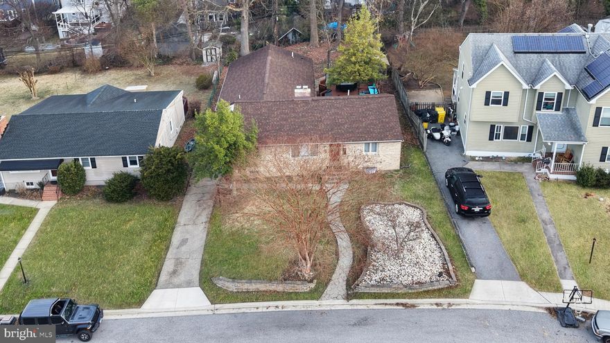 Experience the perfect blend of small-town charm and modern accessibility in this rare main-level living residence. Positioned for an effortless commute to Baltimore, BWI, or the rail station, this 4-bedroom, 2-full-bath home boasts a thoughtful floor plan where the primary living spaces and laundry are all conveniently located on the entry level. The heart of the home features a bright, chef-ready kitchen with durable granite counters and a functional center island for effortless meal prep. Vaulted ceilings in the family room reveal a whimsical loft, evoking the cozy atmosphere of a mountain lodge. Below, a versatile basement serves as a dedicated workshop or creative studio. Outside, the expansive rear deck overlooks a storybook cottage-style shed and a level yard. Off-street parking via a private driveway adds convenience to this quintessential Linthicum Heights location. Essential viewing for those seeking character without compromising on convenience.