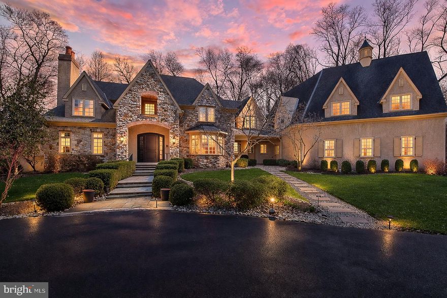 Surrounded by over 155 acres of permanently preserved land, 3525 Wellsford Lane offers something that cannot be replicated: total privacy, unobstructed views, and the certainty that the landscape will never change. Tucked within the exclusive Stoneymead enclave in Buckingham Township, this Trueblood-built French Colonial estate sits on 2.45 manicured acres bordered by 102 acres of conservation-protected Maximuck farmland, 45.8 acres of Buckingham Township preserved open space, and 7.86 acres of unbuildable Stoneymead common land. The setting feels like a private countryside retreat, yet you are just 90 minutes from Midtown Manhattan and minutes from Doylestown, New Hope, and Lambertville.
A circular driveway with fountain leads to the stone and frame facade. Inside, a two-story foyer with grand curved staircase opens to 10,000+ square feet of finished living space across three levels. Hardwood floors, custom millwork, crown moldings, and soaring ceilings set the tone throughout. LED lighting and a holiday candle window lighting package add warmth and efficiency. The two-story great room features a limestone gas fireplace, walnut built-ins, and a wall of windows framing the private grounds. French doors open to an expansive paver terrace with built-in Dacor grill and a heated Anthony Sylvan pool and spa with fountains and waterfall.
The gourmet kitchen is appointed with Wolf six-burner gas range with griddle, Wolf double ovens, warming drawer, Sub-Zero refrigerator/freezer, granite counters, and a center island with prep sink. A convenient laundry chute serves the upper level. A breakfast bar flows into the gathering room with cathedral ceiling, gas fireplace, and built-ins. The main level also includes a formal living room with gas fireplace and built-ins, formal dining room with tray ceiling and bay window, a study with wet bar and Sub-Zero refrigerator drawers, a butler’s pantry with Sub-Zero wine cooler, solarium with cathedral ceiling, laundry room, and a powder room at each end of the home. The oversized heated four-car garage features seamless resinous quartz flooring and a dedicated storage room. Built-in closets throughout the home provide exceptional organization and storage at every turn.
The upper level features five bedrooms and four full bathrooms. The primary suite is a true private oasis: a sitting room, his and hers bathrooms, dual walk-in closets with California Closets systems, and a private hallway creating complete separation from the rest of the home. The chandelier features a key-operated lowering mechanism for easy cleaning and bulb changes. A catwalk overlooking the great room connects to four additional bedrooms, all with California Closets; two are en suite and two share a hall bath. A walk-up attic provides generous walled storage space with potential to finish as an additional retreat.
The finished walk-out lower level adds approximately 3,500 square feet including a billiard room, exercise room, dance studio, granite-top bar and kitchenette, theater-ready media room, full bathroom, second laundry, and generous storage.
Since 2021, the owner has invested significantly in major systems: two new Trane central air conditioning systems (2021, 2022), a new high-efficiency Noble boiler (2022), a new Franklin submersible well pump with constant pressure controller (2025), new pool pump and start capacitor (2023, 2024), new pool cover, new sewer pump (2021) and ongoing HVAC maintenance. Five climate-control zones, whole-house sound system, central vacuum, security system, and indoor sprinkler system complete the package.
Award-winning Central Bucks School District (Cold Spring Elementary, Holicong Middle, CB East). Easy access to Routes 202, 413, and 611. A rare opportunity to own a truly private estate where the land around you is protected forever.